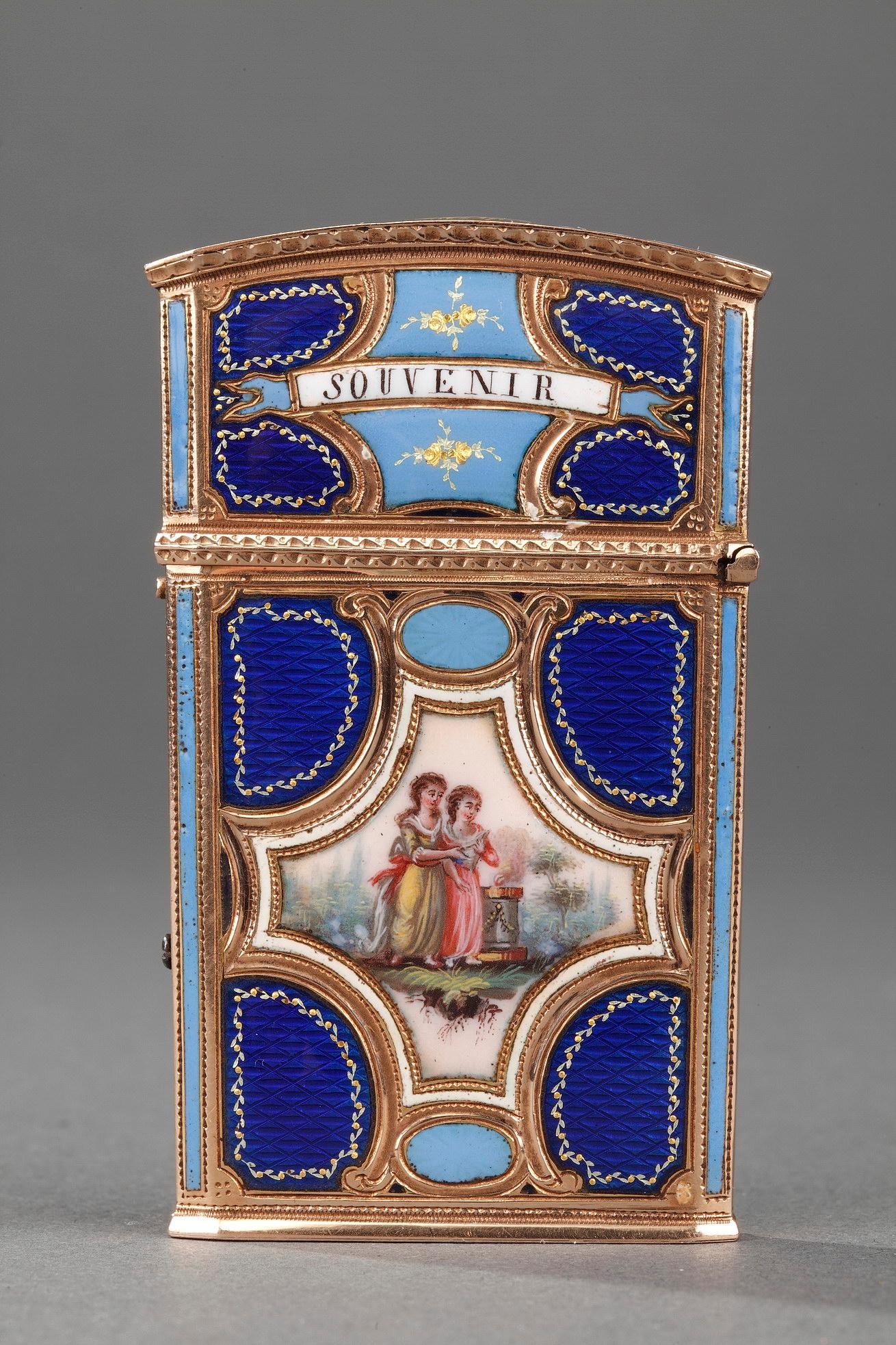 Flat trapezoidal shaped tablet case in enamelled gold. The upper part is hinged and opens with a push-button. The case is composed of four translucent blue-enameled translucent panels showing a fine cross-guilloche pattern. They are enhanced by a