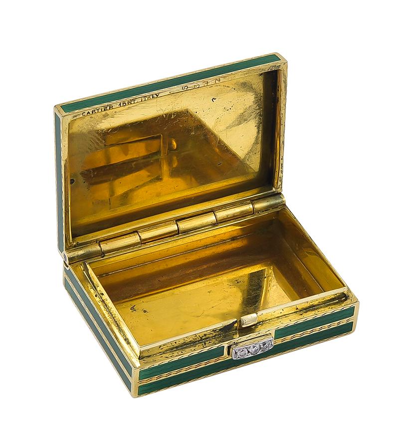 Most elegant pill box.  Made, signed and numbered by CARTIER.  Heavy gauge 18K yellow gold.  Allover engine-turned pattern, intersecting with emerald green guilloche enamel.  The clasp is set with three diamonds.  The box opens when the clasp is