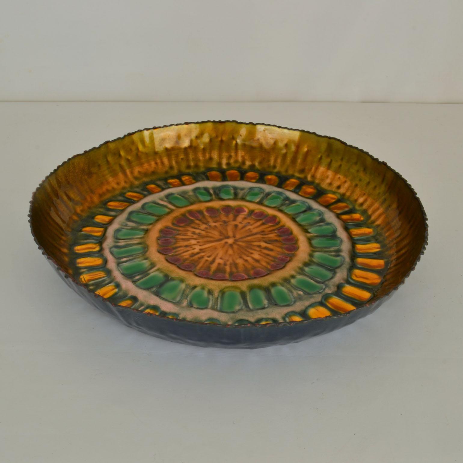 Enamelling is one of the oldest and most precious of crafts and the decorative round bowl with its sun ray of transparent brilliant bright gold and green. The jewel-like surface is a modern take on an old tradition. The turned rim as an irregular