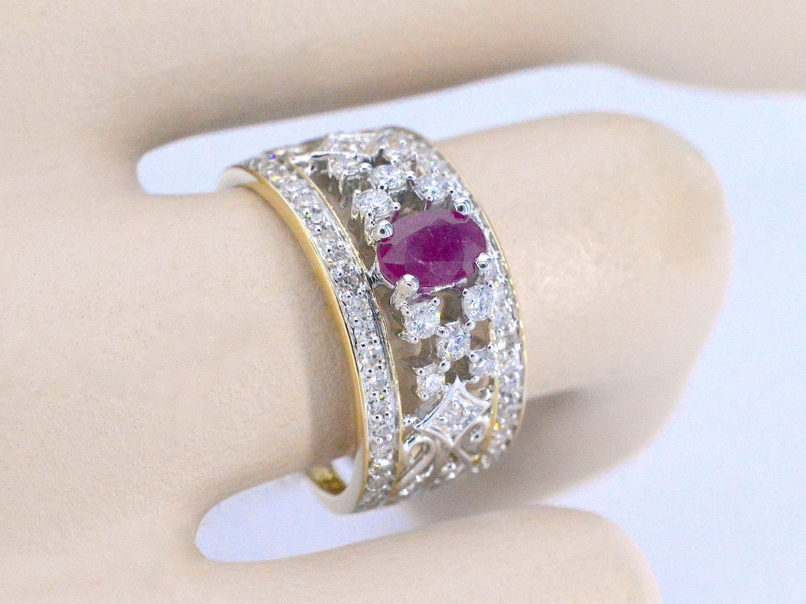 Questo esclusivo anello d'oro è un gioiello di grande effetto, con diamanti scintillanti e uno splendido rubino. I diamanti sono sapientemente incastonati nella fascia d'oro per creare un look elegante e senza soluzione di continuità che cattura la