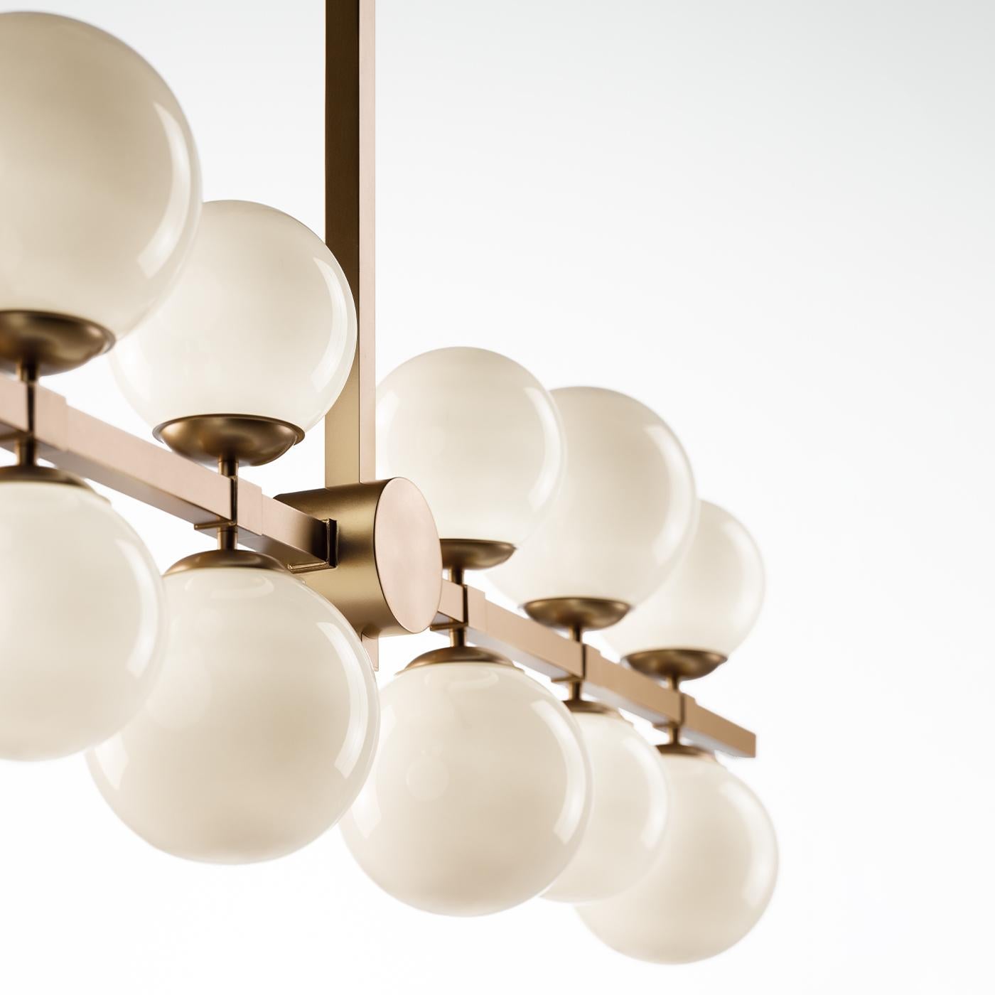 A masterpiece of light and style, this stunning chandelier features a squared metal rod with a gold finish, elegantly supporting 12 white glass spheres, all illuminated to create a dramatic and enveloping effect. Luxurious and modern, it’s perfect