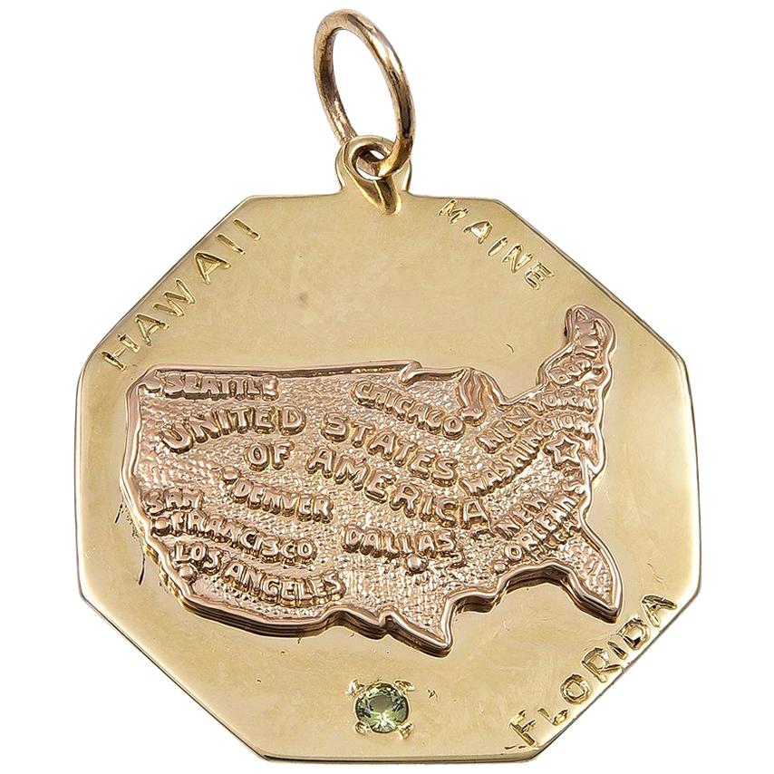 Large octagonal charm.  In the center is an applied figural map of the United States, embossed with names of major cities.  Engraved around the border:  