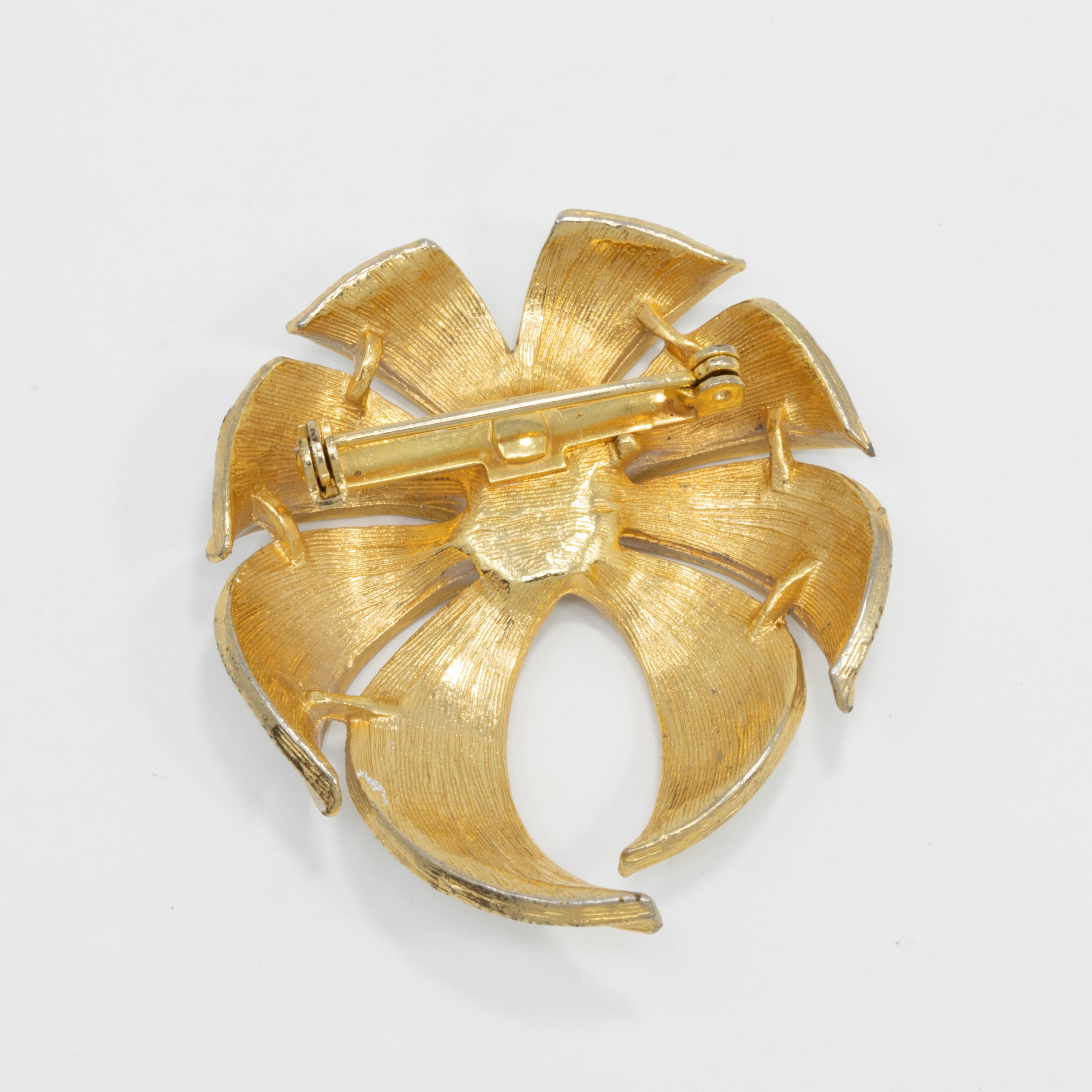 A golden flower, painted with lily-white enamel - the perfect touch of class!

Circa mid to late 1900s.

Gold-plated. Light wear of enamel on top brooch.
