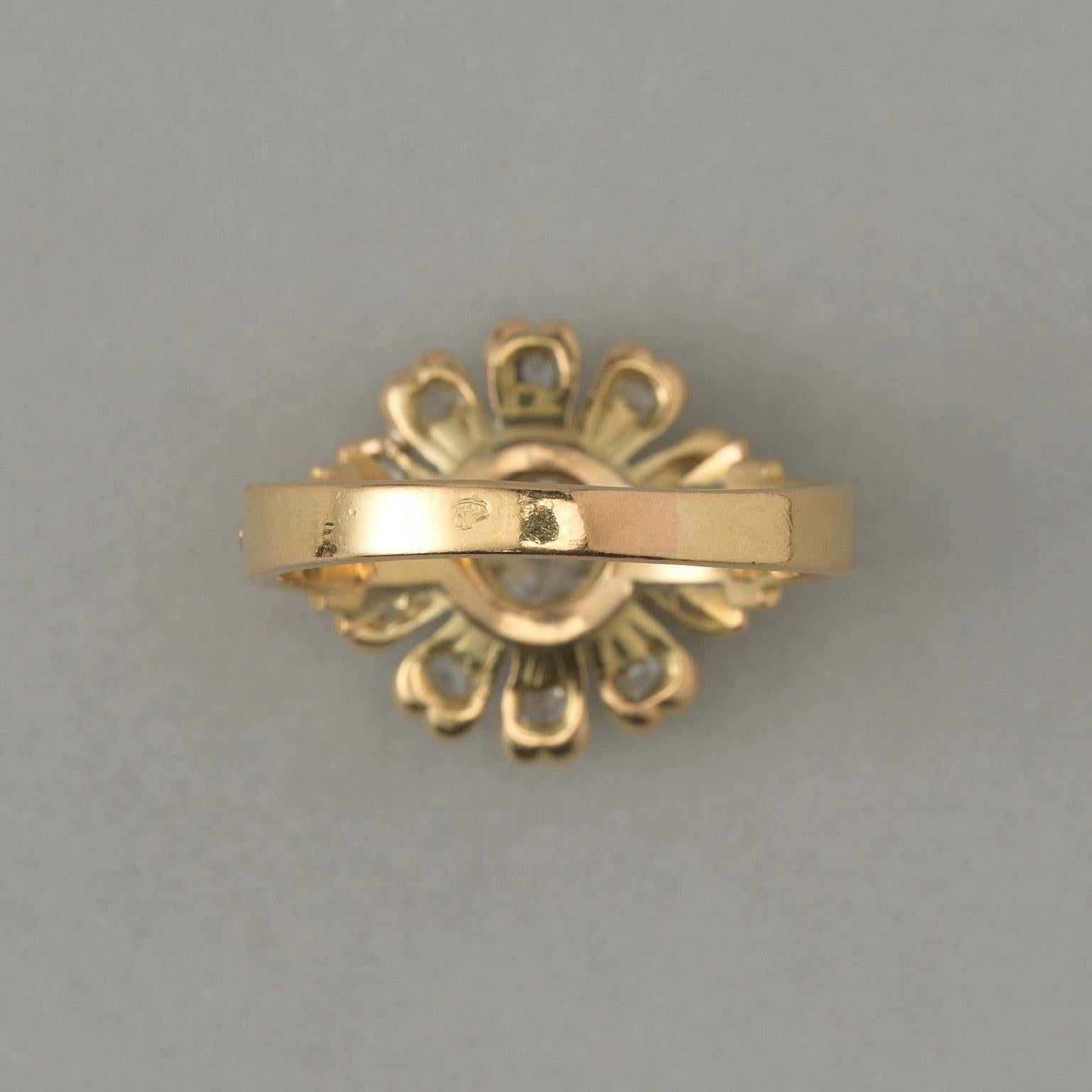 An 18 carat yellow gold flower ring. The flower is set with a large old cut diamond (app. 0.67 carat) set at the heart of the flower, the ten petals are set with small rose-cut diamonds in different shapes and sizes. (app. 1.07 carat in total),