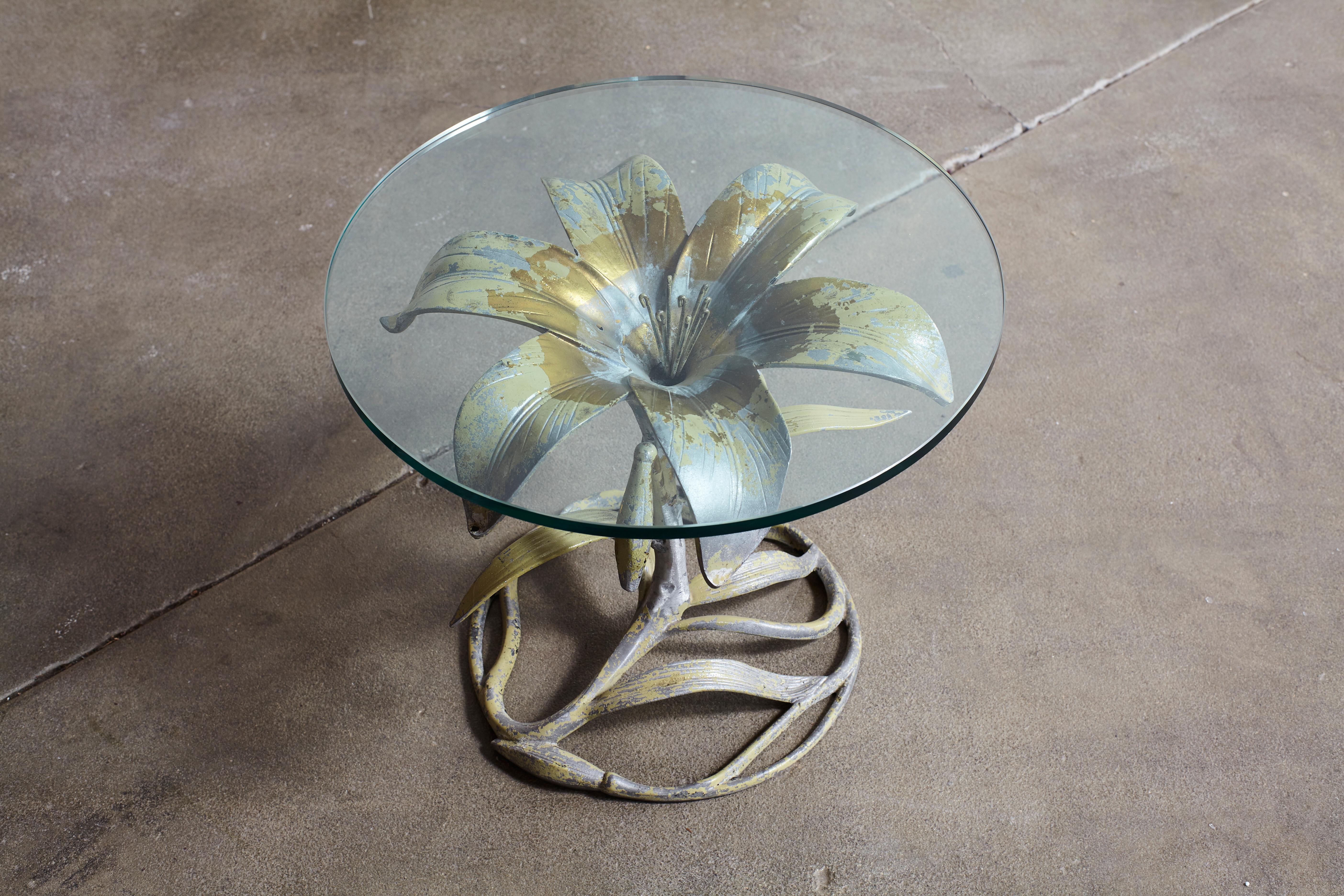 Gold flower shaped side table with glass top.