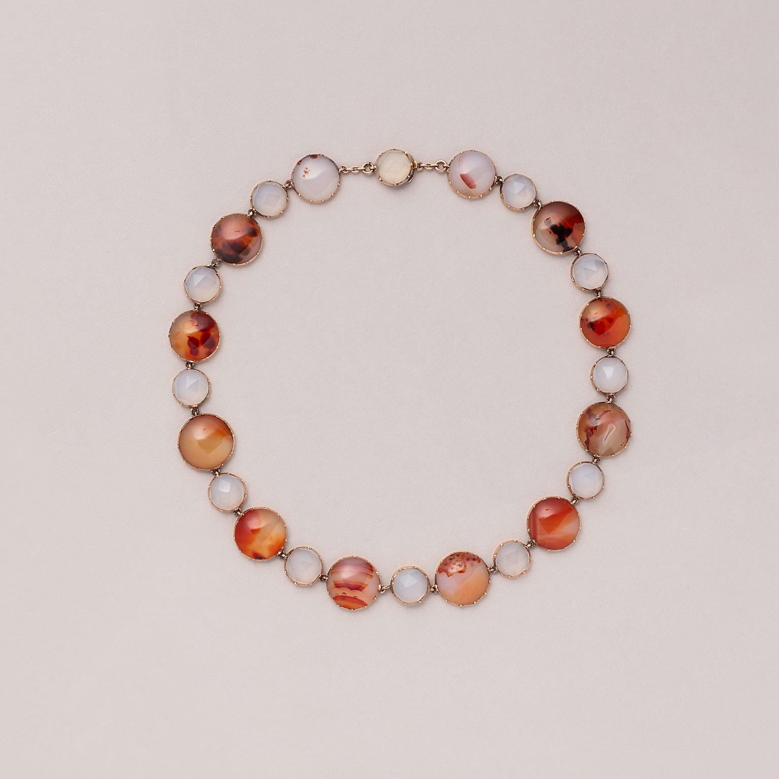 Collana in oro rosato a 12 carati con corniola arancione tagliata a cabochon e agata calcedonia bianca e grigia tagliata a rosa, fine XVIII secolo o inizio XIX secolo, Inghilterra.

peso:  33,62 grammi
lunghezza: 39 cm
larghezza: 11 - 15 m