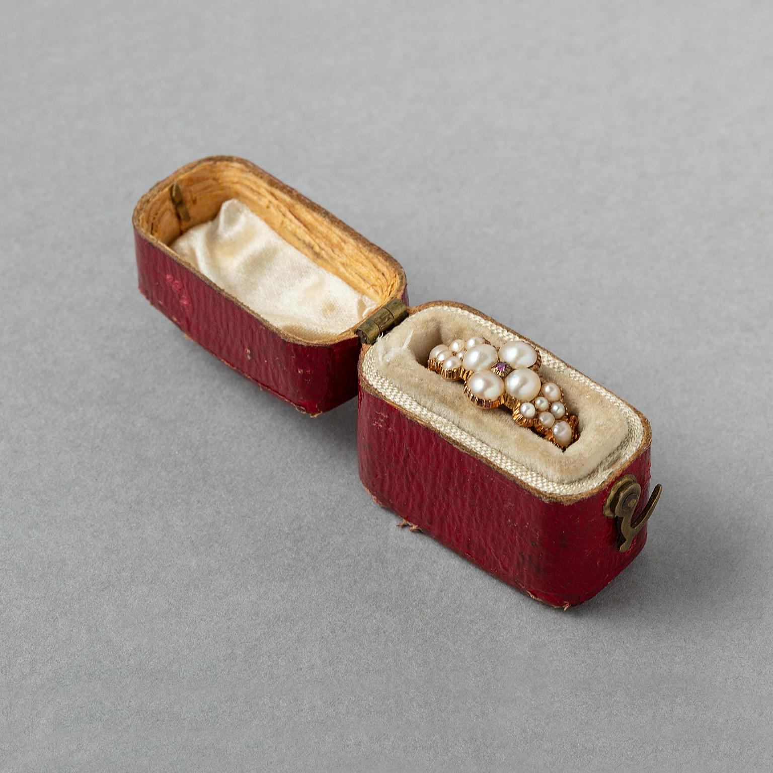 A gold Georgian ring with a four-pass decorated with half pearls and also on the shank all in cut away setting with forked florally decorated shoulders, England, circa 1830 in original red case.

weight: 2.21 g
ring size: 15.45 mm / 5 US