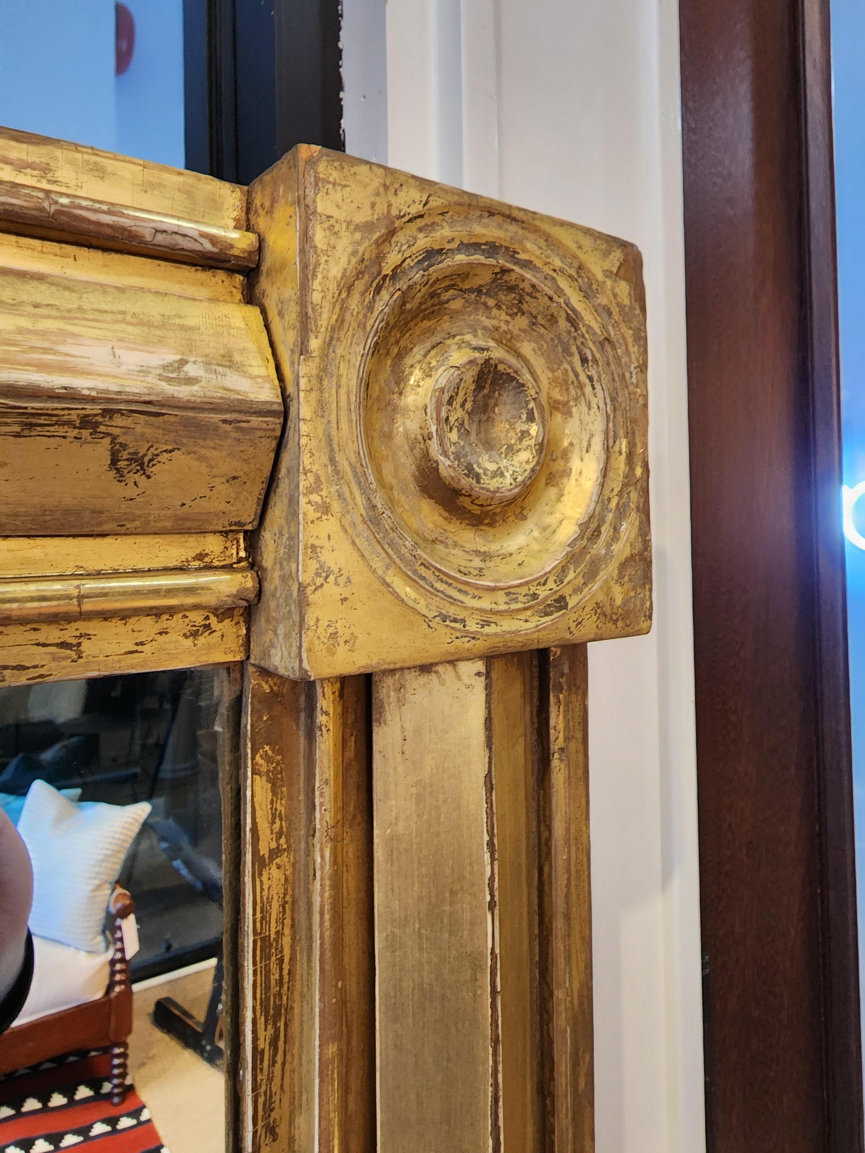 An American federal mirror of exceptional quality depth and design. With a perfect warm patina and retaining the original gold gilding and mirror glass. Stunning and bold this unusually shaped American classical mirror is perfect for any interior.