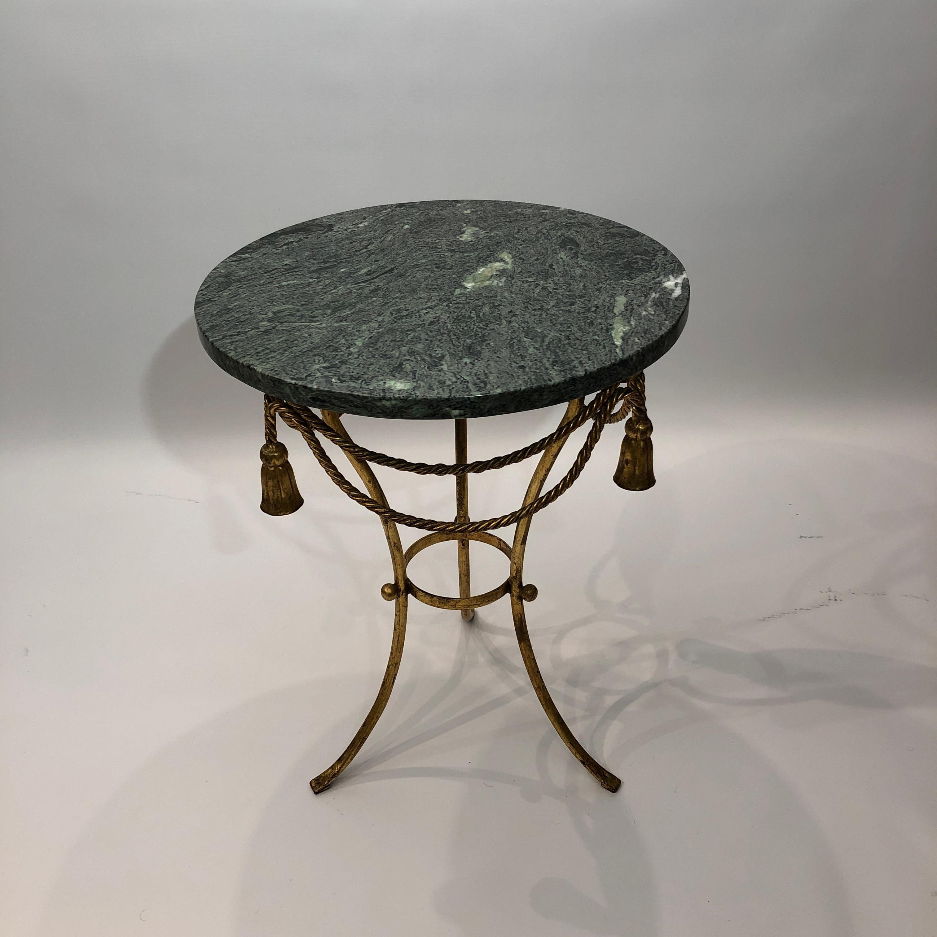 Ein eleganter Beistelltisch in einem Eisengestell mit vergoldetem Blatt, das Seile und Quasten darstellt und eine runde grüne Marmorplatte trägt. Ein wunderbares Stück praktischen Designs, das sich leicht in jedes Interieur einfügt, ob Vintage oder