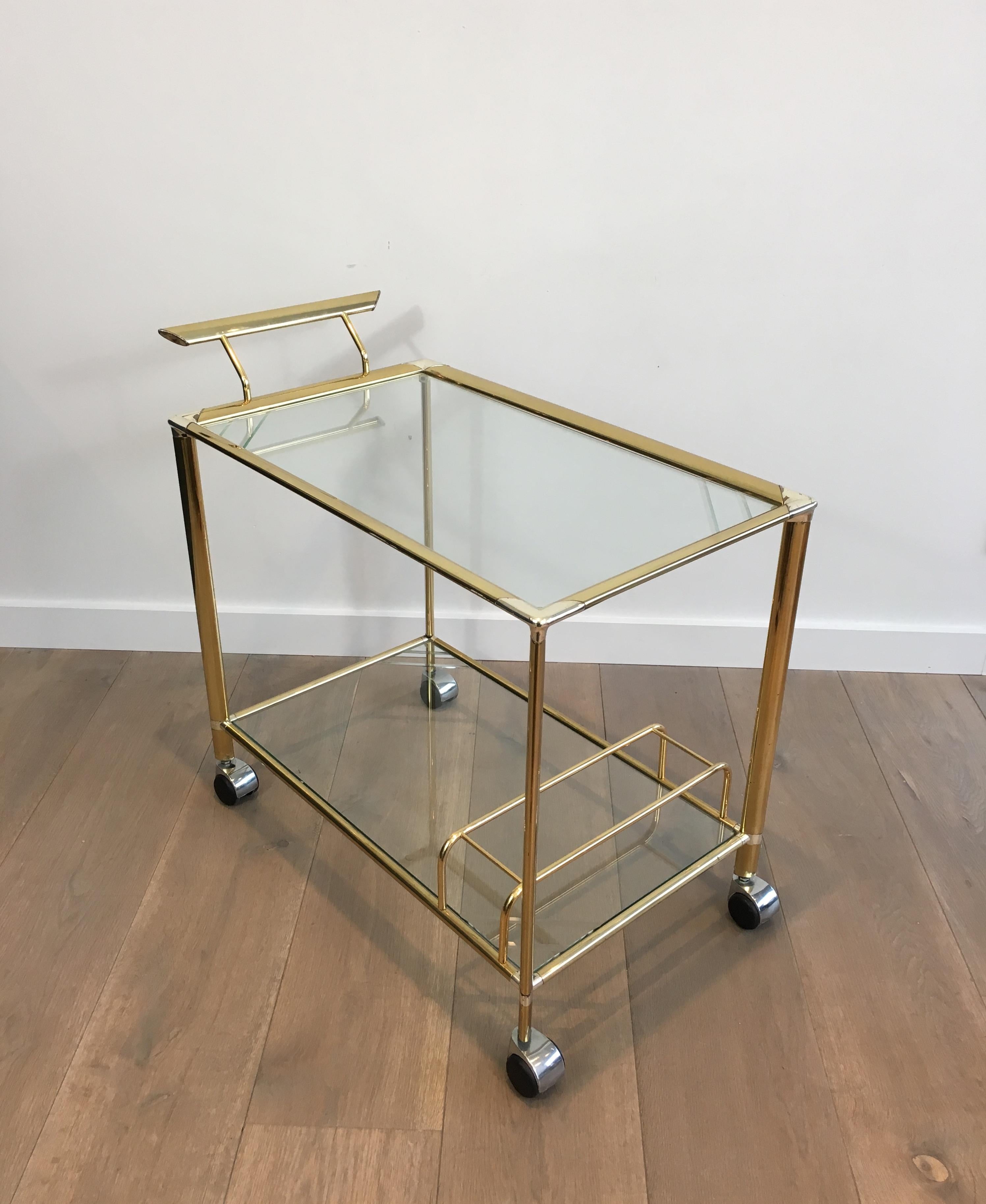 This unusual drinks trolley is made of gold gilt brass and silver plated metal. The glass shelves have engraved lines. This is a French work, circa 1970.