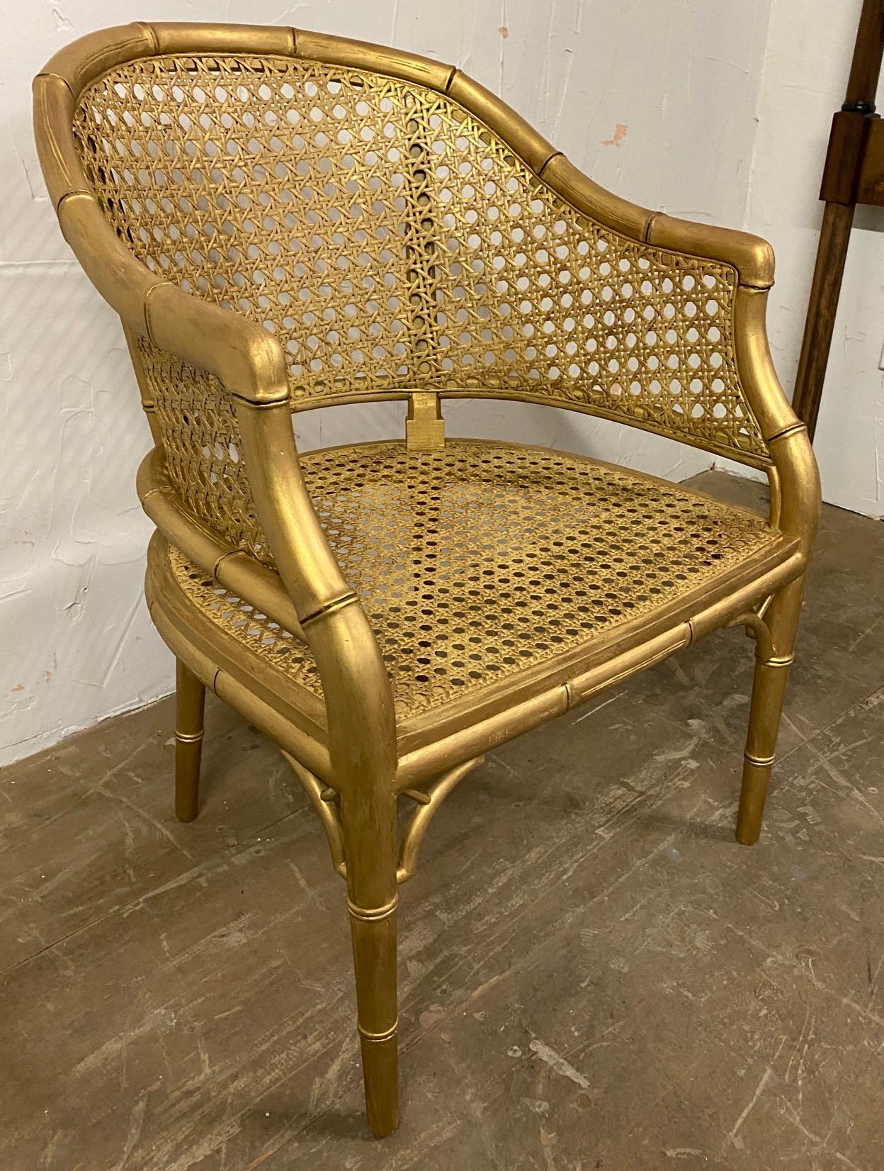 The very stylish Chinese Chippendale style faux bamboo barrel back armchair has a woven caned back and seat and a rubbed gilt finish. A great pull-up chair for any room. 
Search terms: Hollywood regency, Chinoiserie.

Measures: Arm H 26