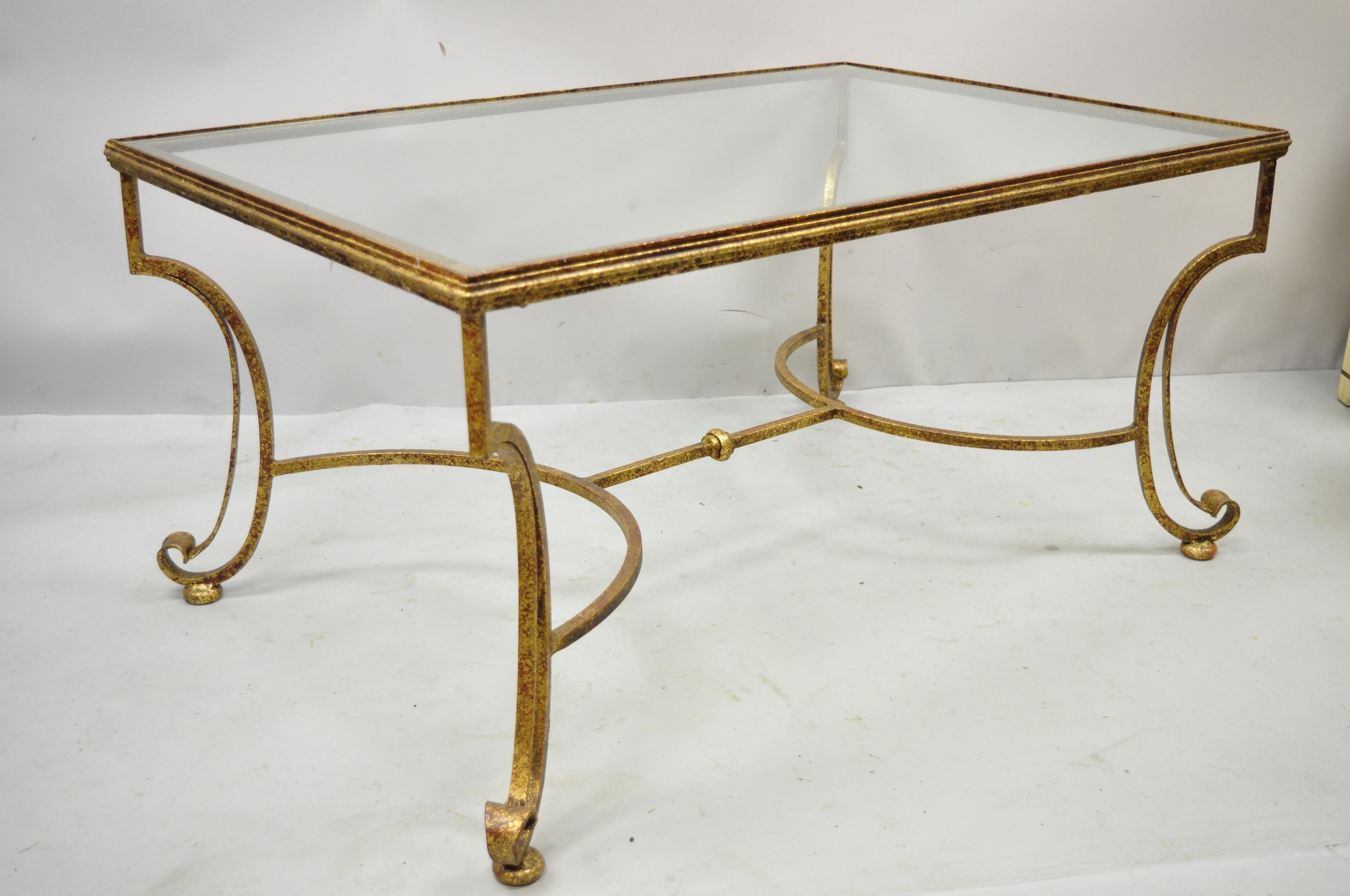 Gold gilt iron scroll glass top Italian Hollywood Regency rectangular coffee table. Item features glass top, wrought iron construction, distressed gold gilt finish, quality craftsmanship, sleek sculptural form. Circa Late 20th Century. Measurements: