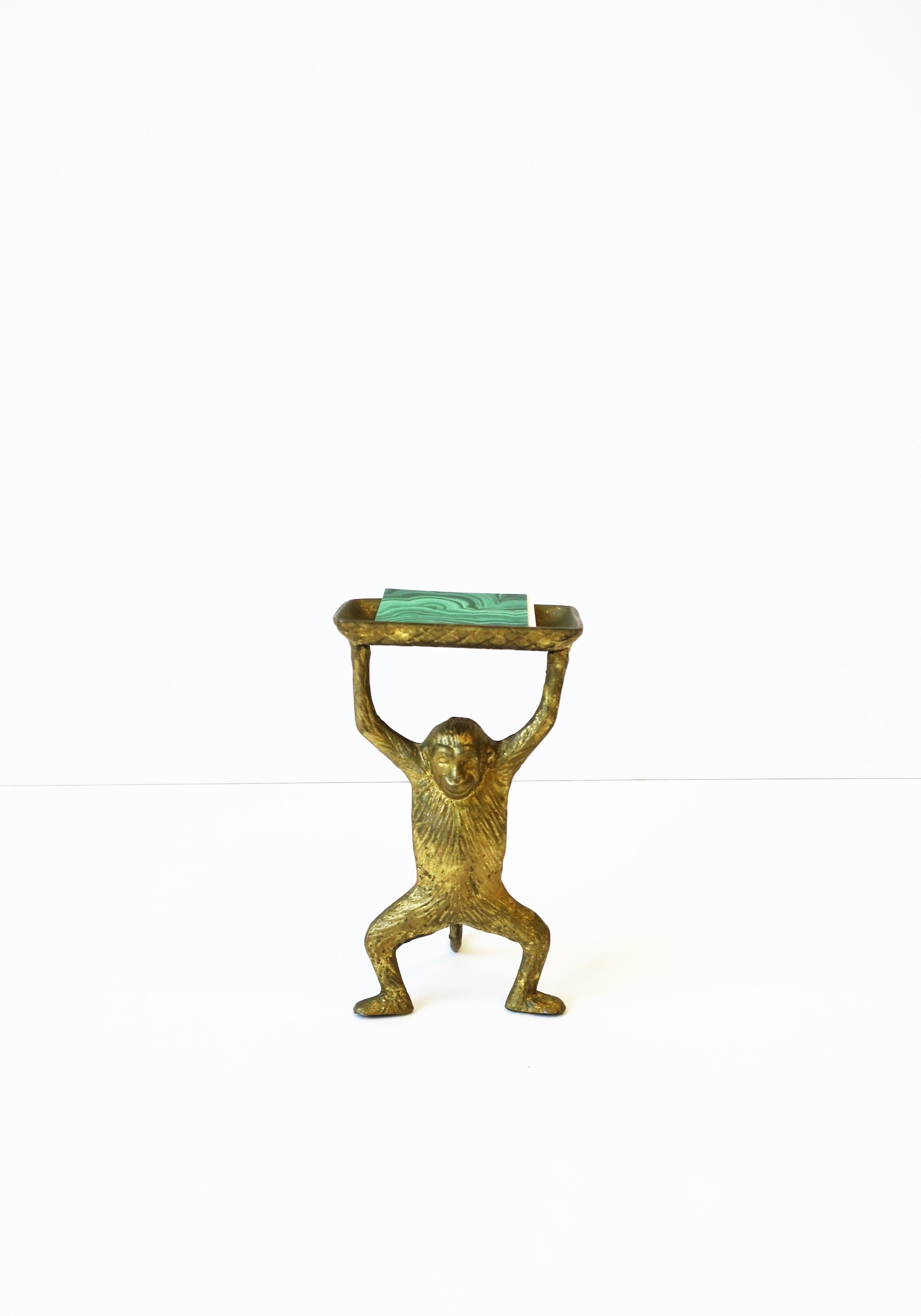 A gold gilt metal monkey holding a tray decorative object, circa late-20th century. A great desk accessory to hold business cards or other small items or as a standalone decorative object. Dimensions: 3