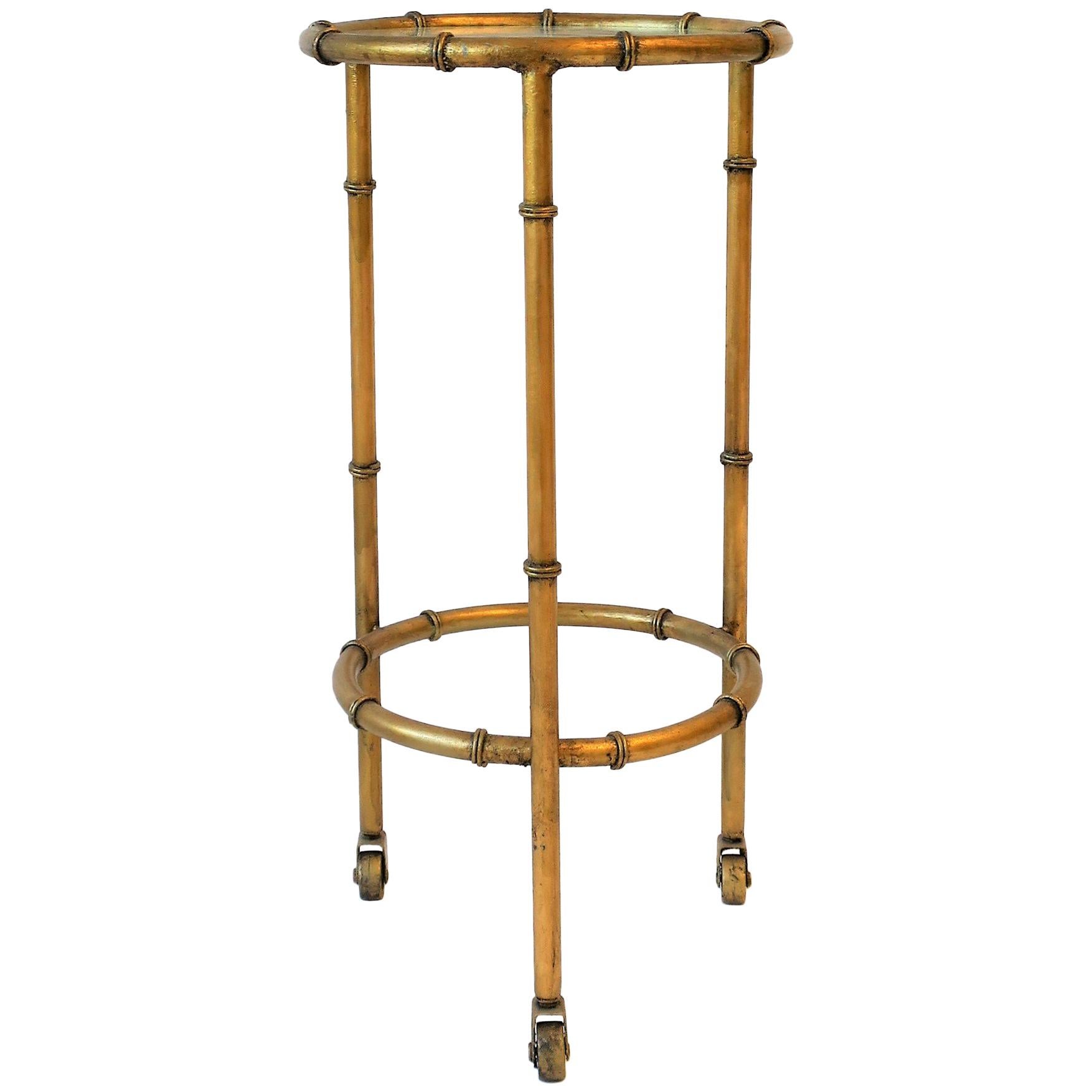 A beautiful round gold gilt metal and glass top side or drinks table on small caster wheels. 

Table measures: 23