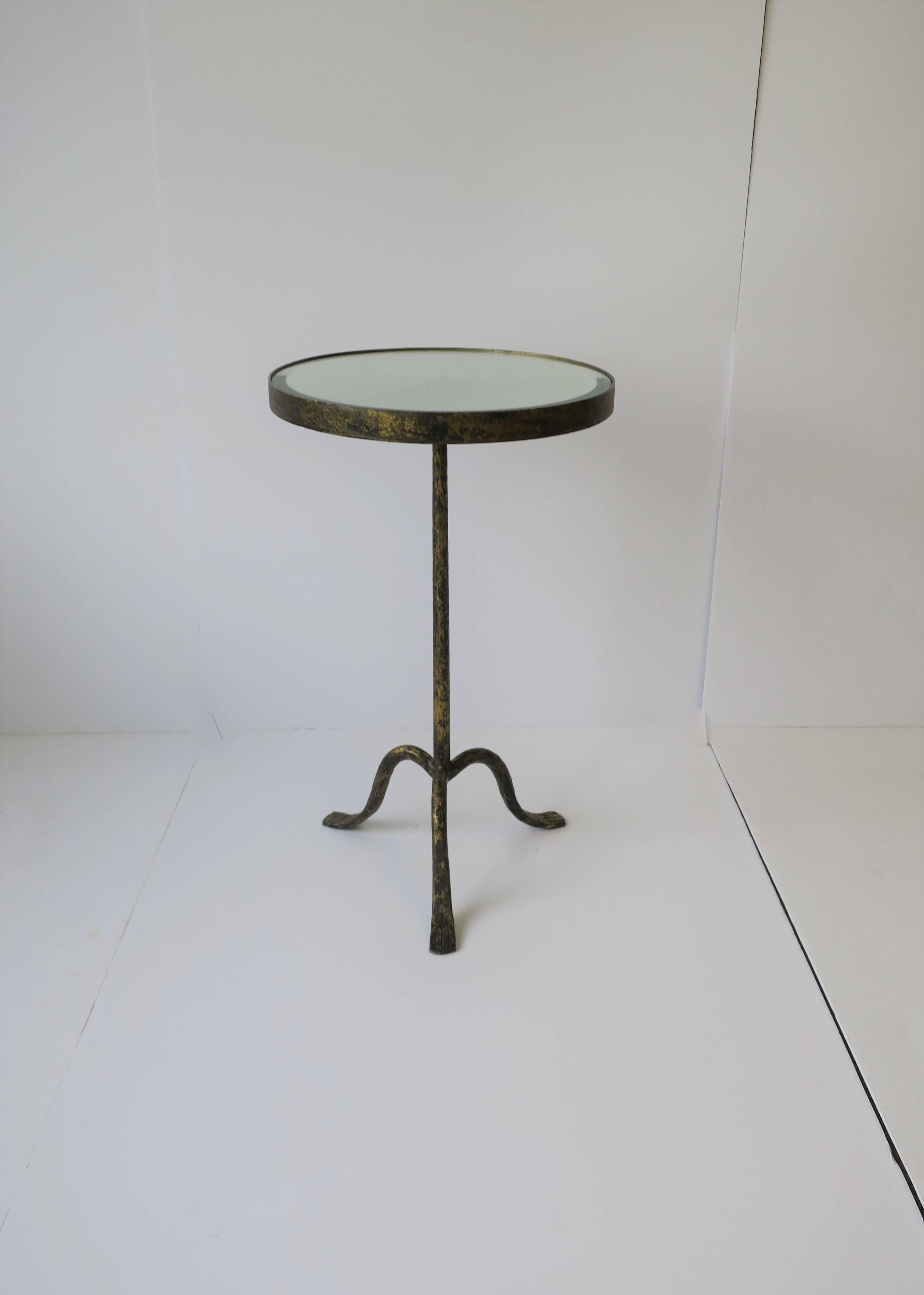 A beautiful gold gilt metal round Gueridon side or drinks table with mirrored glass top and tri-pod paw/leg base, circa 21st Century. 

Side table measures: 14