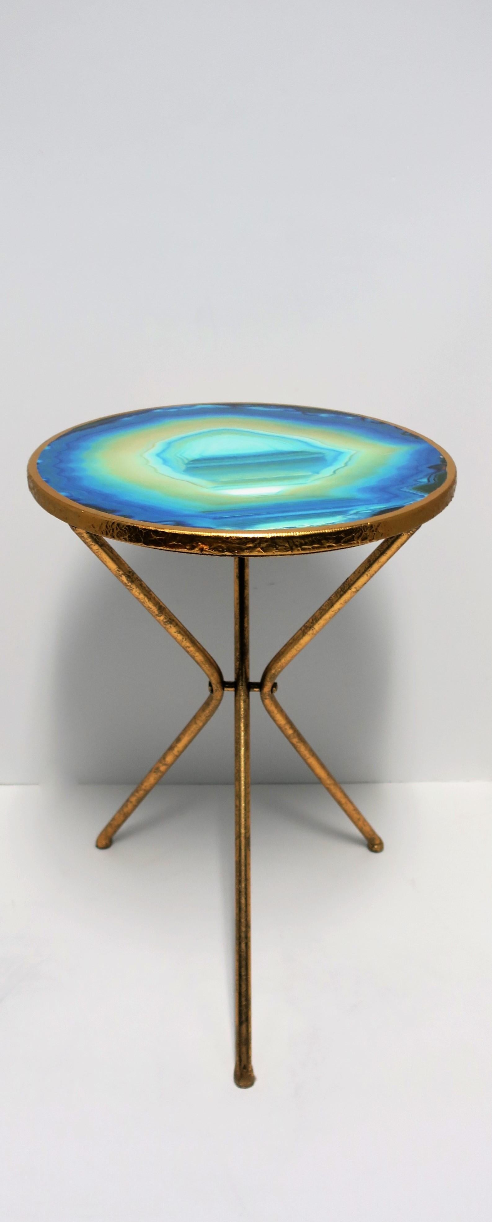 A beautiful and fun round gold gilt side or drinks table with agate style top. Table depicts a faux agate specimen piece top, gold gilt edge/sides, and tri-pod legs, circa 21st century. 

Table measures: 16