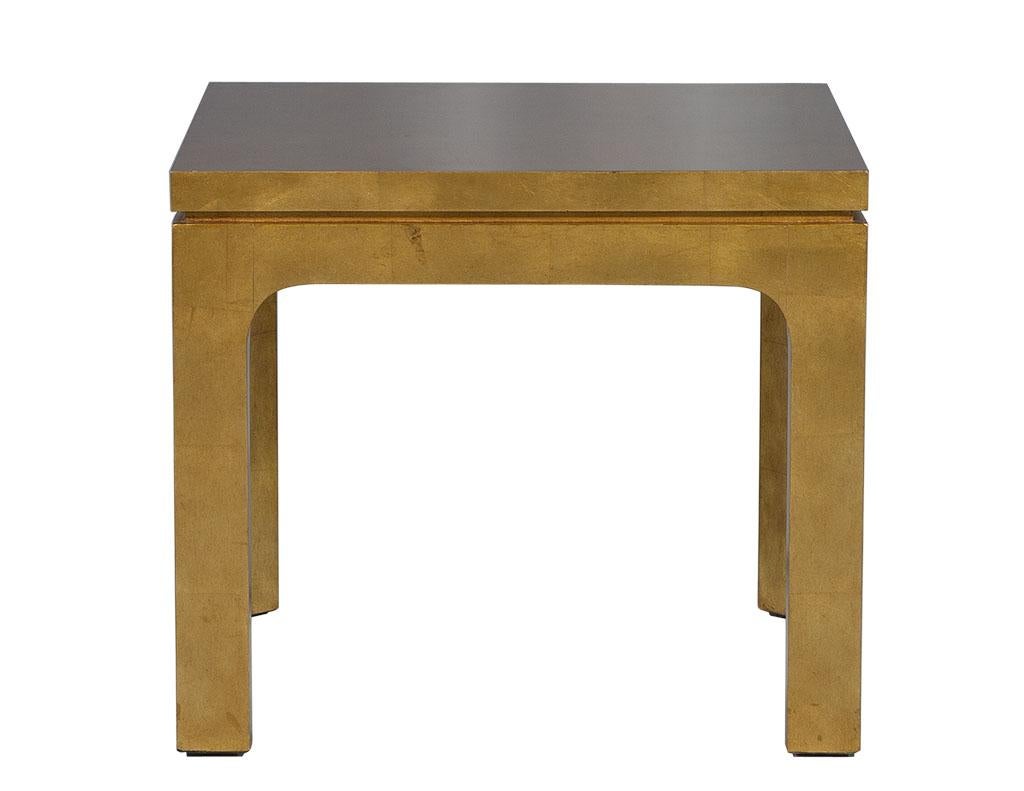 Table d'appoint en or doré. Cette table d'appoint contemporaine est un véritable coup de cœur. Fabriqué en bois doré avec des panneaux carrés sur le dessus pour ajouter de la profondeur. Une pièce magnifique pour un espace de vie aventureux.

Le