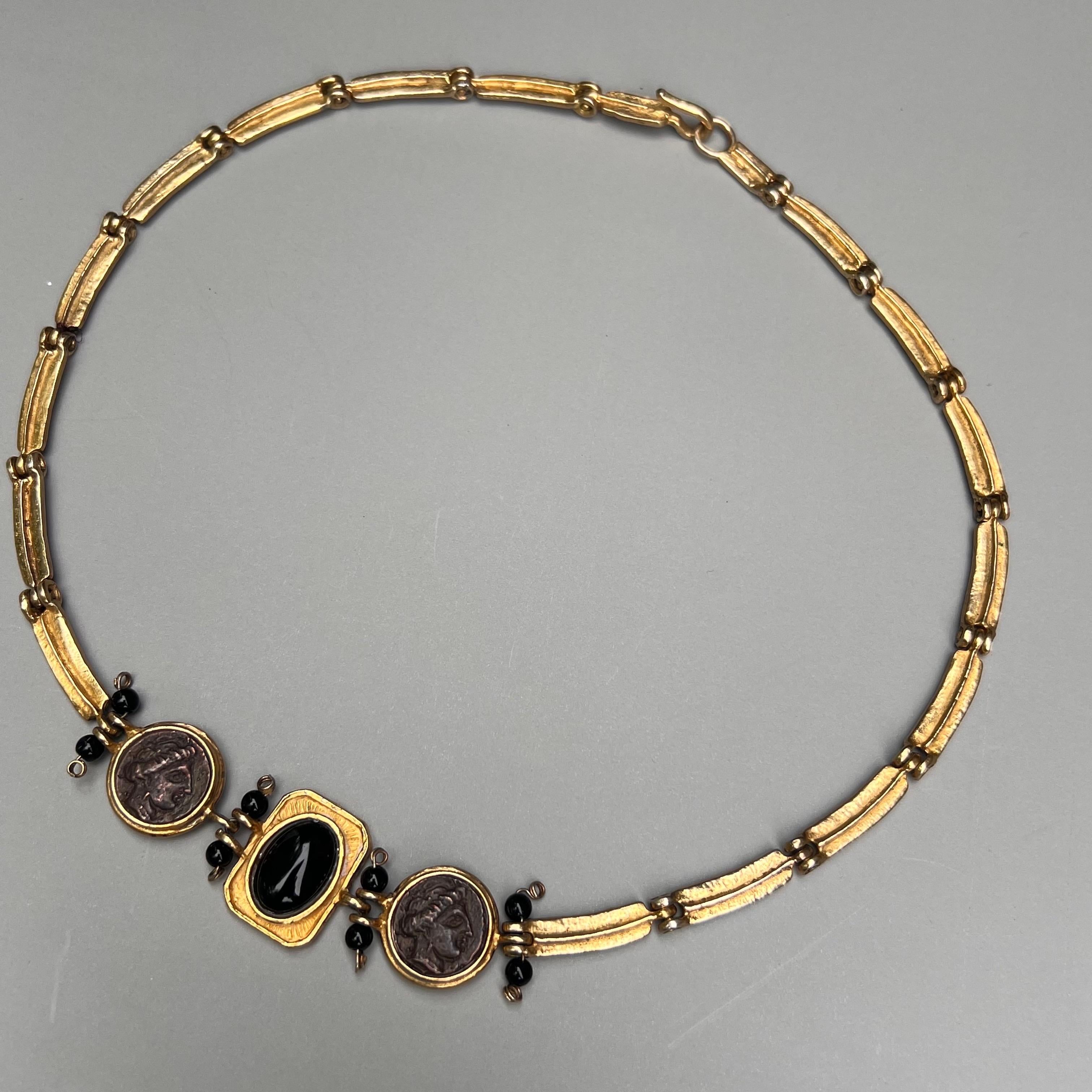 This necklace boasts an unsigned designer allure, hand crafted with gold gilt sterling silver, evoking a sense of vintage glamour and mystery.
Adorned with faux Roman coins, the necklace captures the essence of ancient mythology and adds a touch of