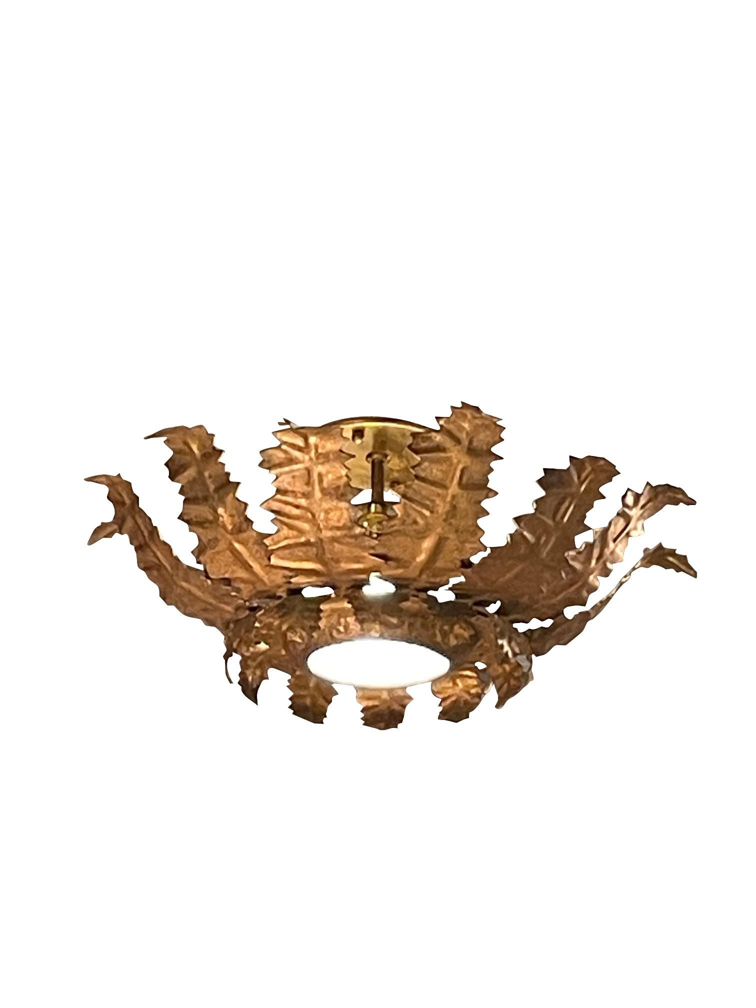 1940's Spanish gold gilt metal sunburst design ceiling mount chandelier.
Glass center piece.
Newly rewired and UL listed.
Single candelabra bulb.
Two available and sold individually.