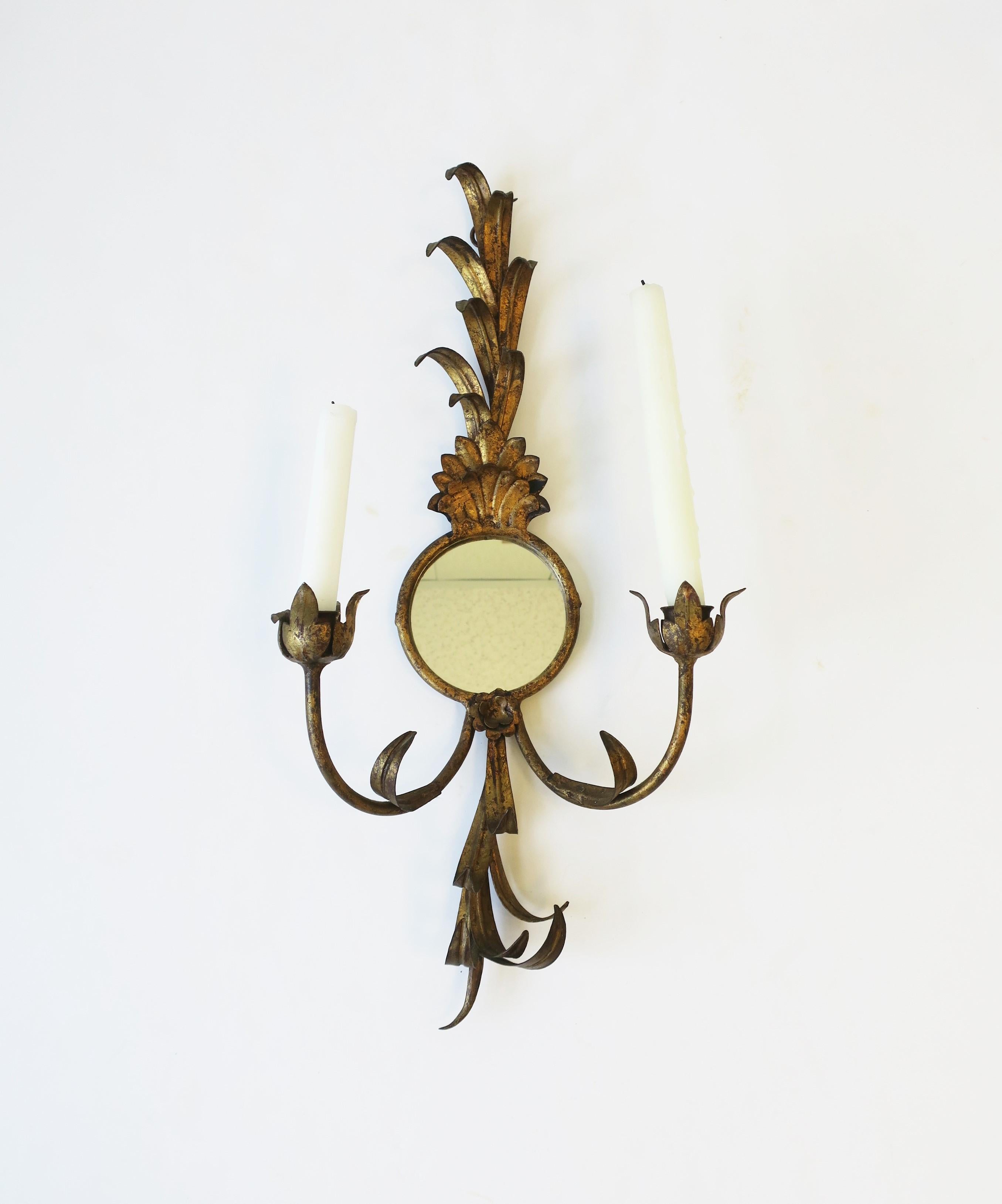 A gold gilt tole metal and mirror sheaf-of-wheat candle wall sconce, circa early-21st century. Holds two candles as demonstrated. Small round mirror at center. Dimensions: 5.25