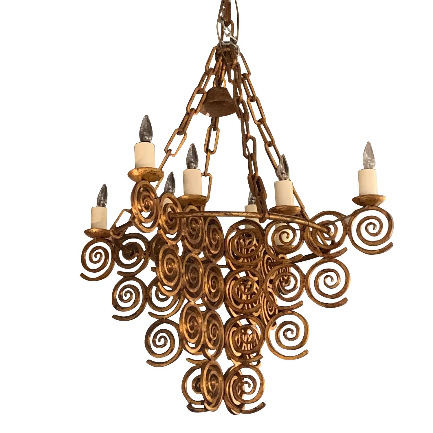 1950s Spanish gold gilt wrought iron eight-arm chandelier
There are four panels composed of wrought iron swirls. These meet in the center and connect to a circular rod.
Two candelabras sit atop each 