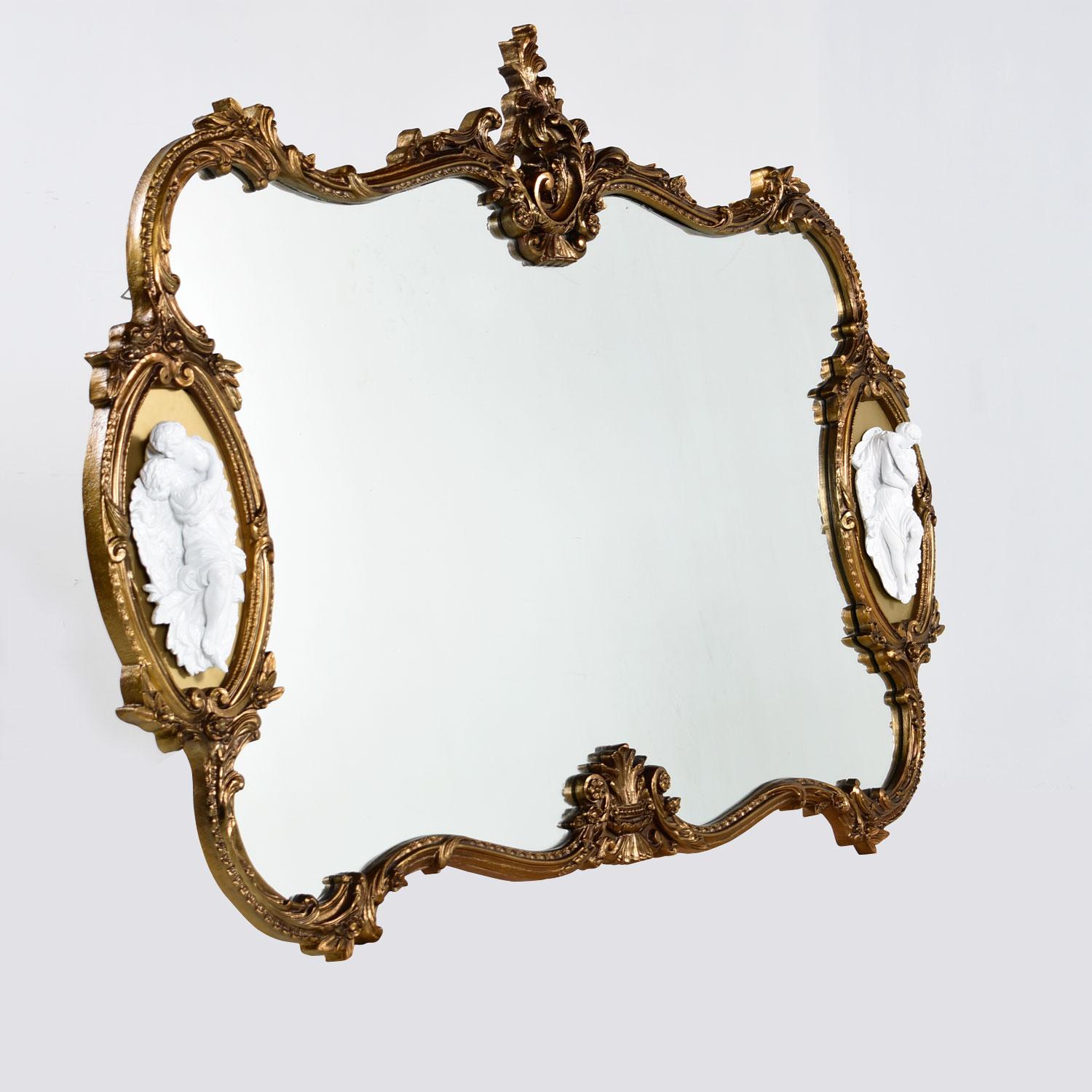 Massive, elegant, gold giltwood baroque mirror with scroll work frame. Faux ebony white lacquered figural reliefs on the left and right sides of this mirror add another layer of decadence.

Mirror is in outstanding condition.