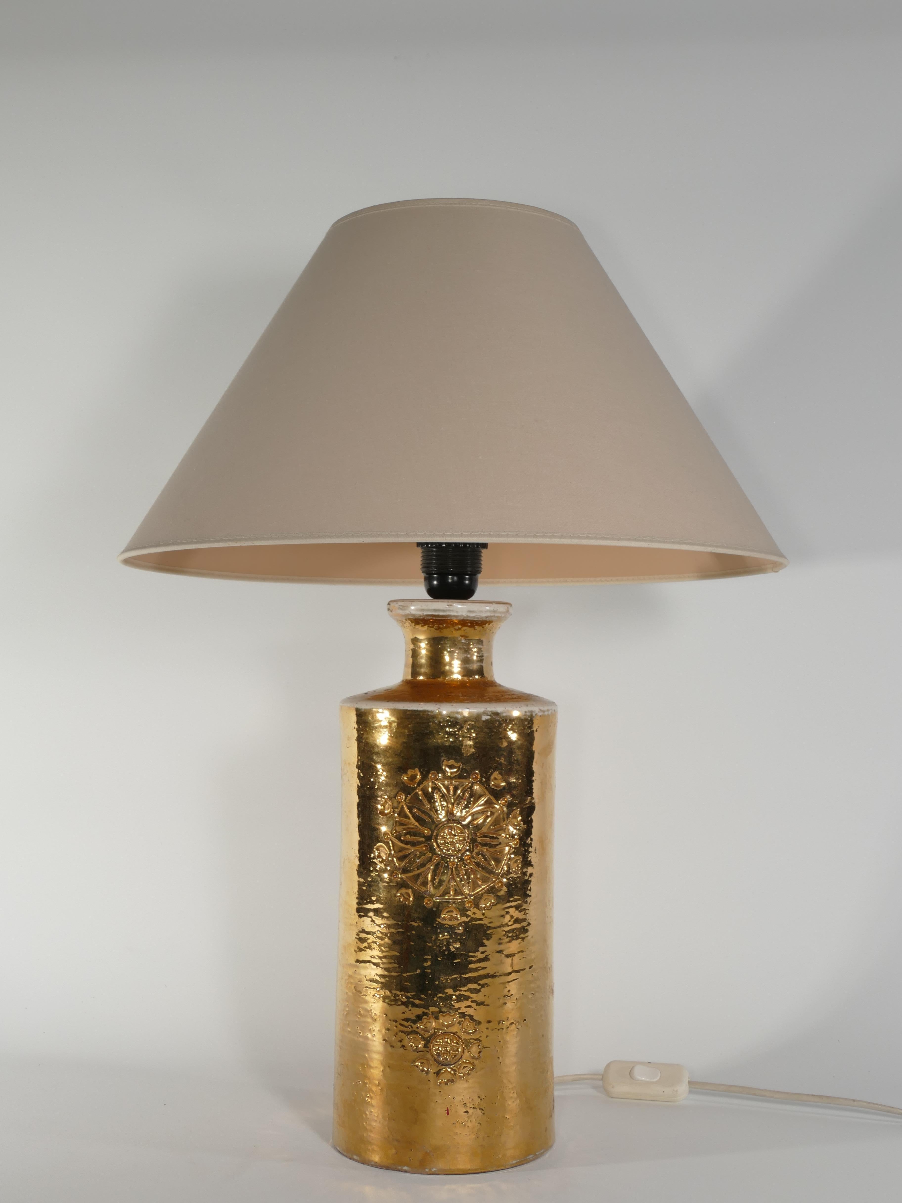 A ceramic table lamp by Bitossi for Bergboms, featuring a luxurious 22-Karat Gold Glaze.

Presenting a striking table lamp crafted by Bitossi for Bergboms, these pieces showcase exquisite 22-karat gold glazed ceramic adorned with delicate floral