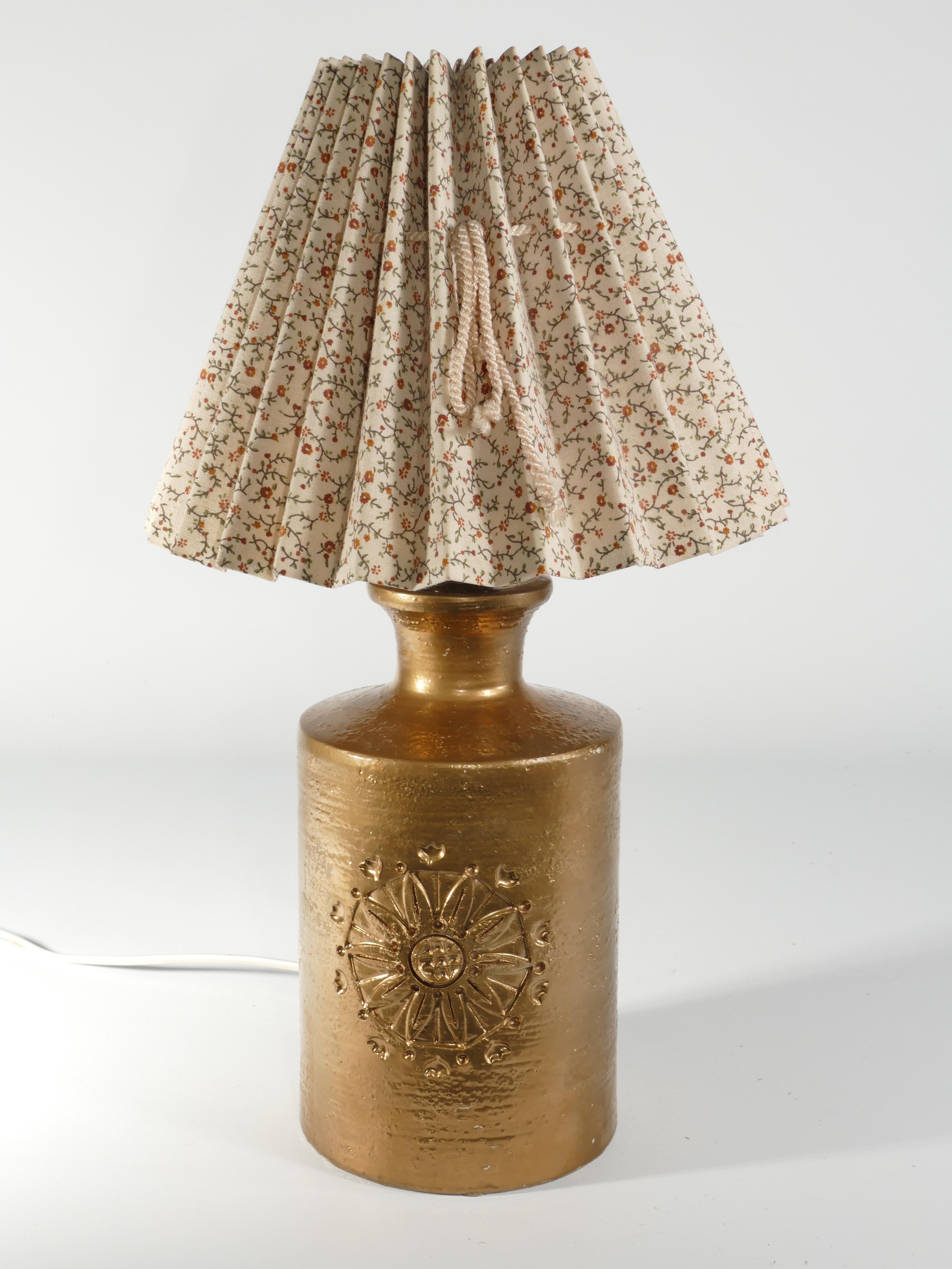A ceramic table lamp by Bitossi for Bergboms, featuring a luxurious 22-Karat Gold Glaze.

Presenting a striking table lamp crafted by Bitossi for Bergboms, these pieces showcase exquisite 22-karat gold glazed ceramic adorned with delicate floral