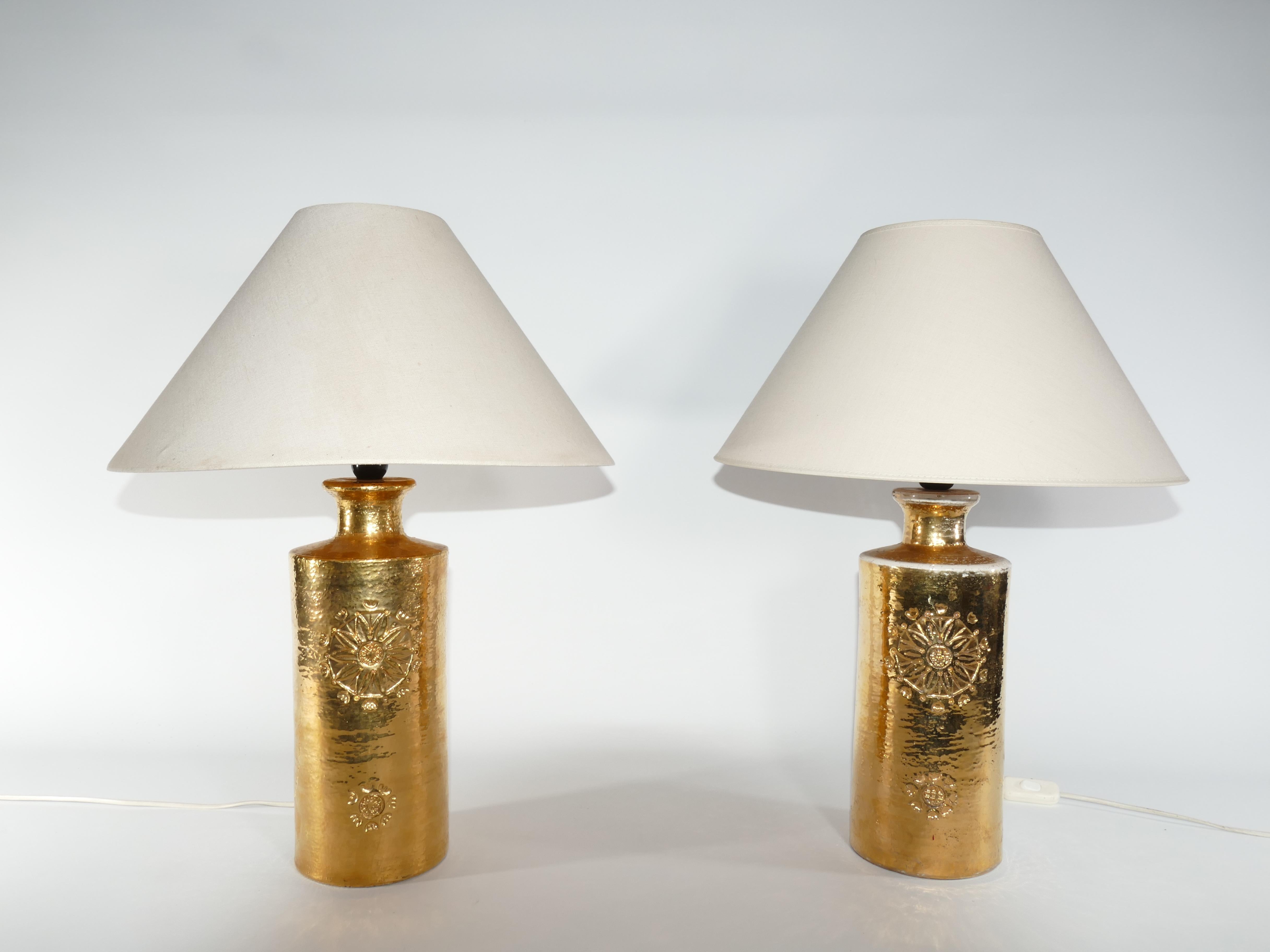 A set of ceramic table lamps by Bitossi for Bergboms, featuring a luxurious 22-Karat Gold Glaze.

Presenting a striking pair of table lamps crafted by Bitossi for Bergboms, these pieces showcase exquisite 22-karat gold glazed ceramic adorned with