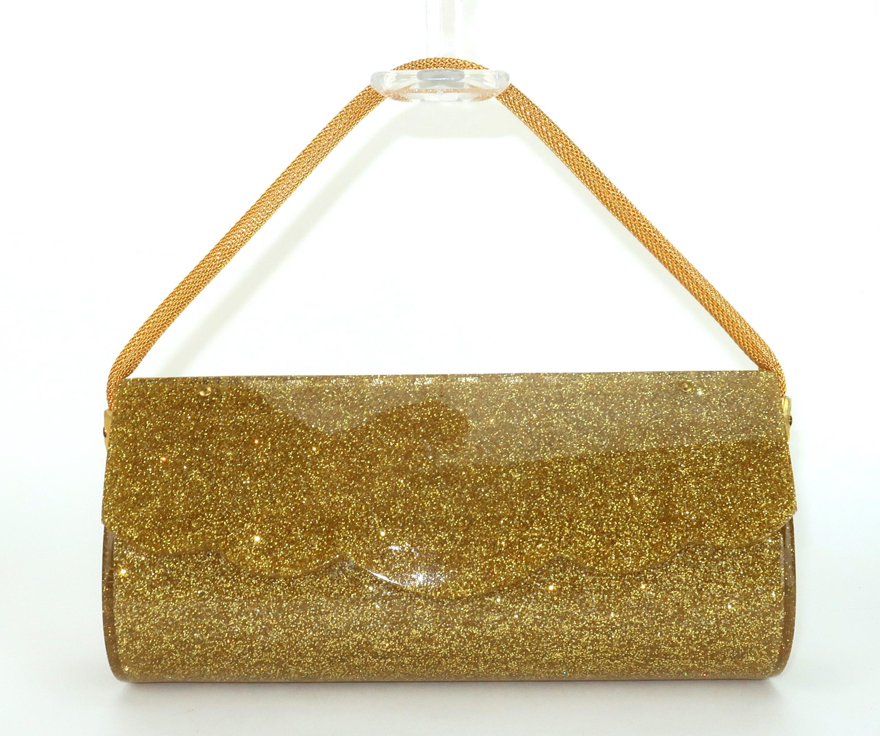 Get the Midas touch with this 1950’s gold glitter lucite evening handbag with metal rope handle and a springloaded closure decorated by a scalloped detail.  The teardrop shaped profile provides a surprisingly roomy interior with enough space for