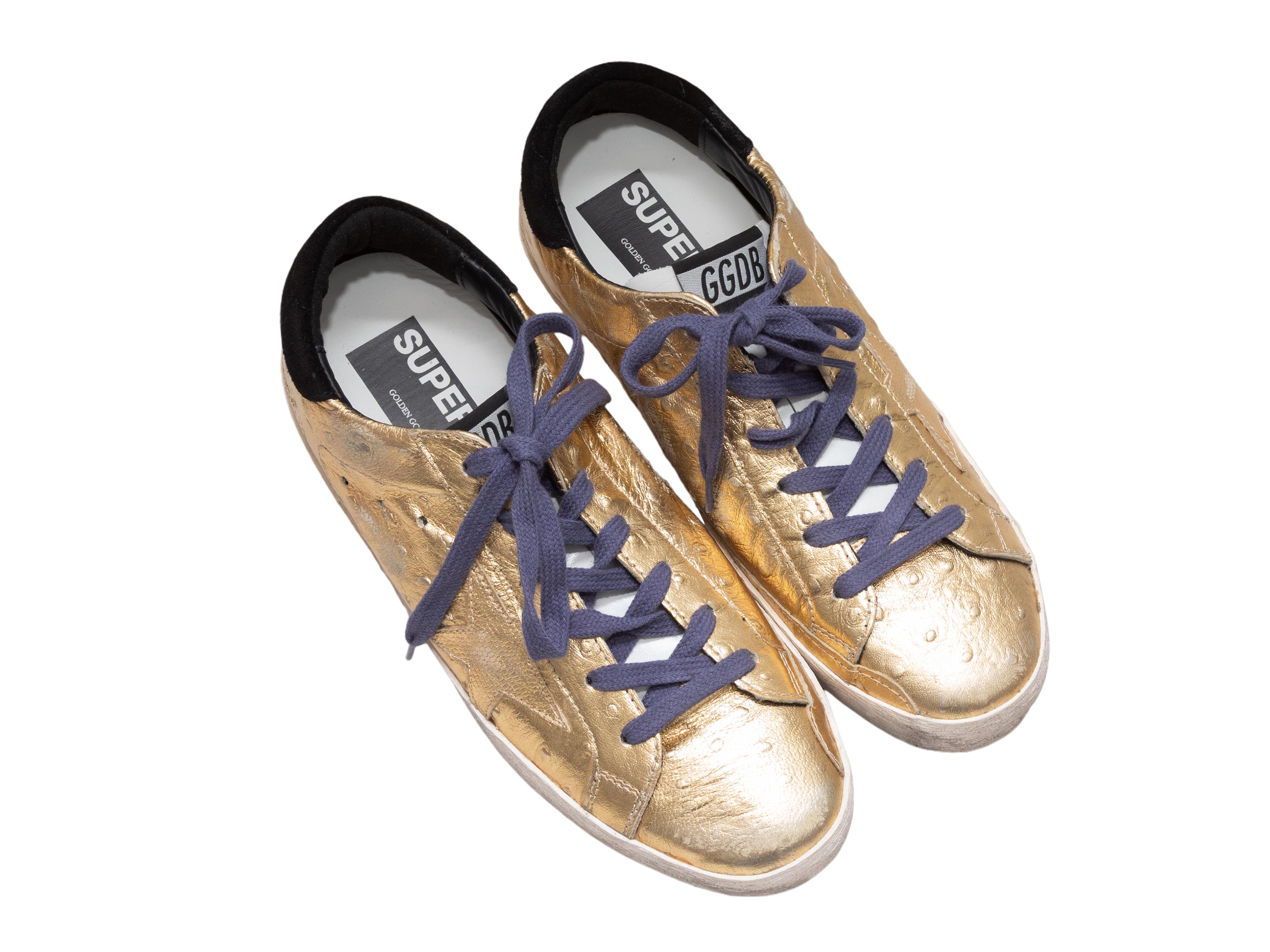 Goldene Metallic-Sneaker aus Leder von Golden Goose. Durchgehend bewusste Beunruhigung. Sohlen aus Gummi. Schnürsenkelverschlüsse an der Spitze. 1