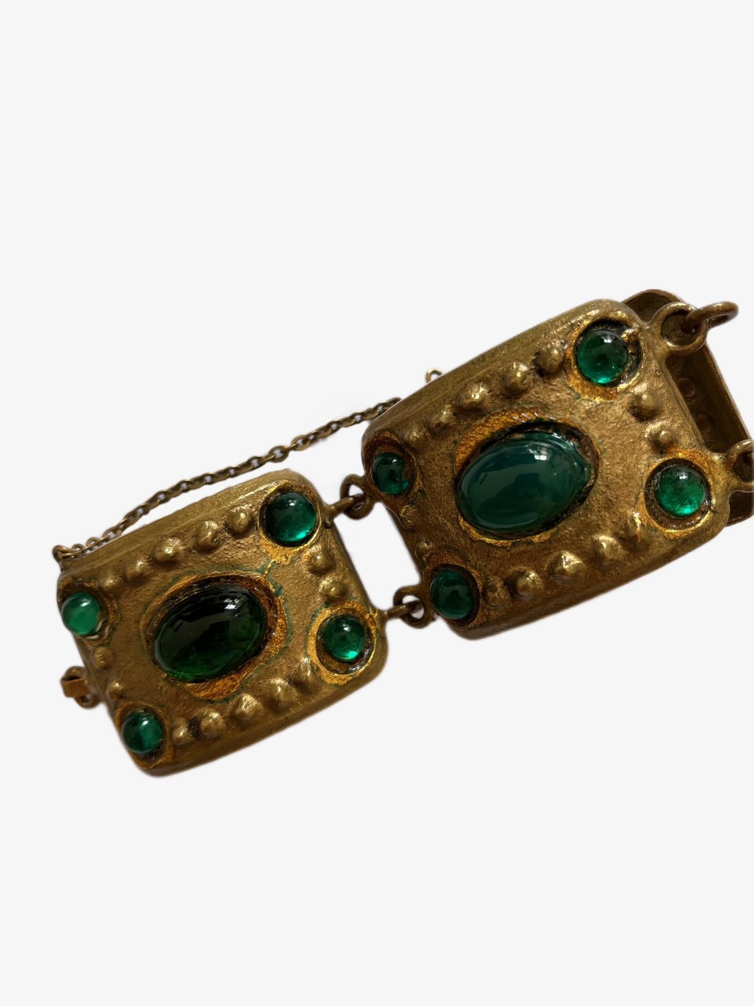 This striking vintage bracelet features large, ornate square metal panels in an antique gold-tone finish. Each panel is adorned with oval green cabochons that create a bold and luxurious look. Smaller round green stones surround the central oval