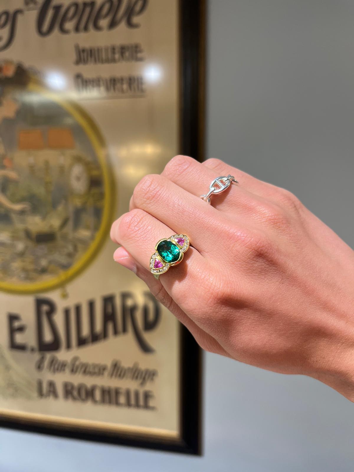 An 18 karat yellow gold, green tourmaline, pink sapphire, and diamond three stone ring. 

Here is a contemporary, somewhat vintage 80s feeling take on a classic three stone made for someone with an ardent love of color. The center stone is a