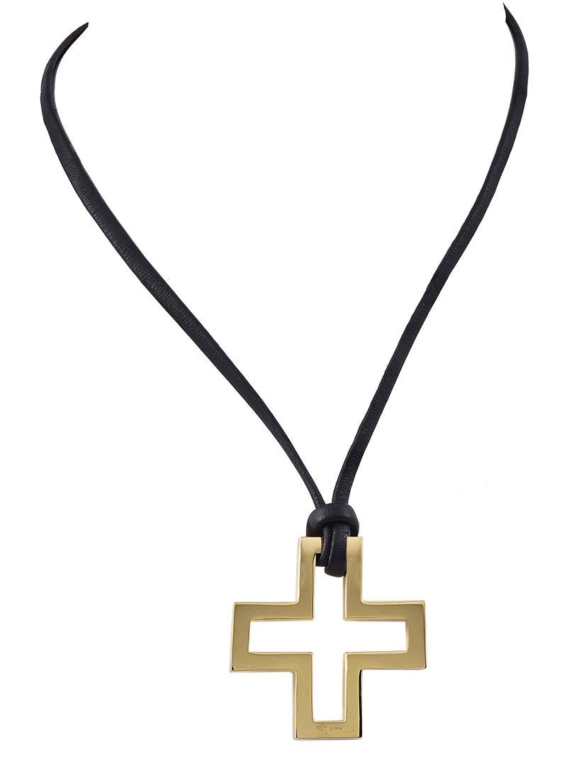 Open geometric cross.  Made and signed by GUCCI.  18K yellow gold.  On a black silk cord, with a gold clasp.  1 1/4