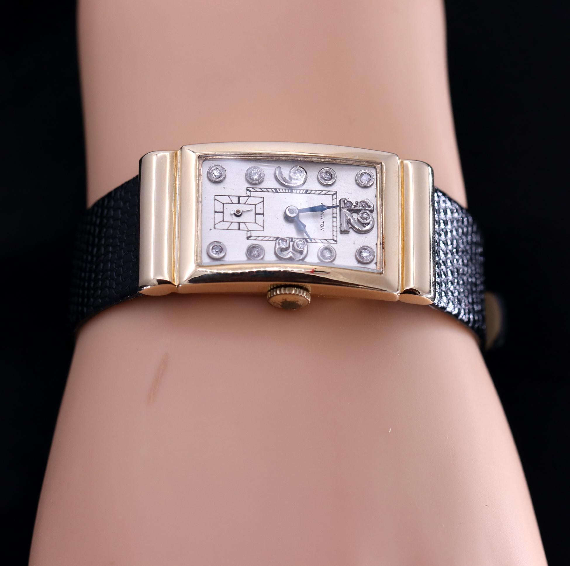 Originally designed as a men's watch, but just as popular with women today, this 14 karat yellow gold wristwatch has a case measuring 42mm X 20mm. The dial is a nice silvery white with diamond markers, and diamond numerals at the 12, 3, and 9