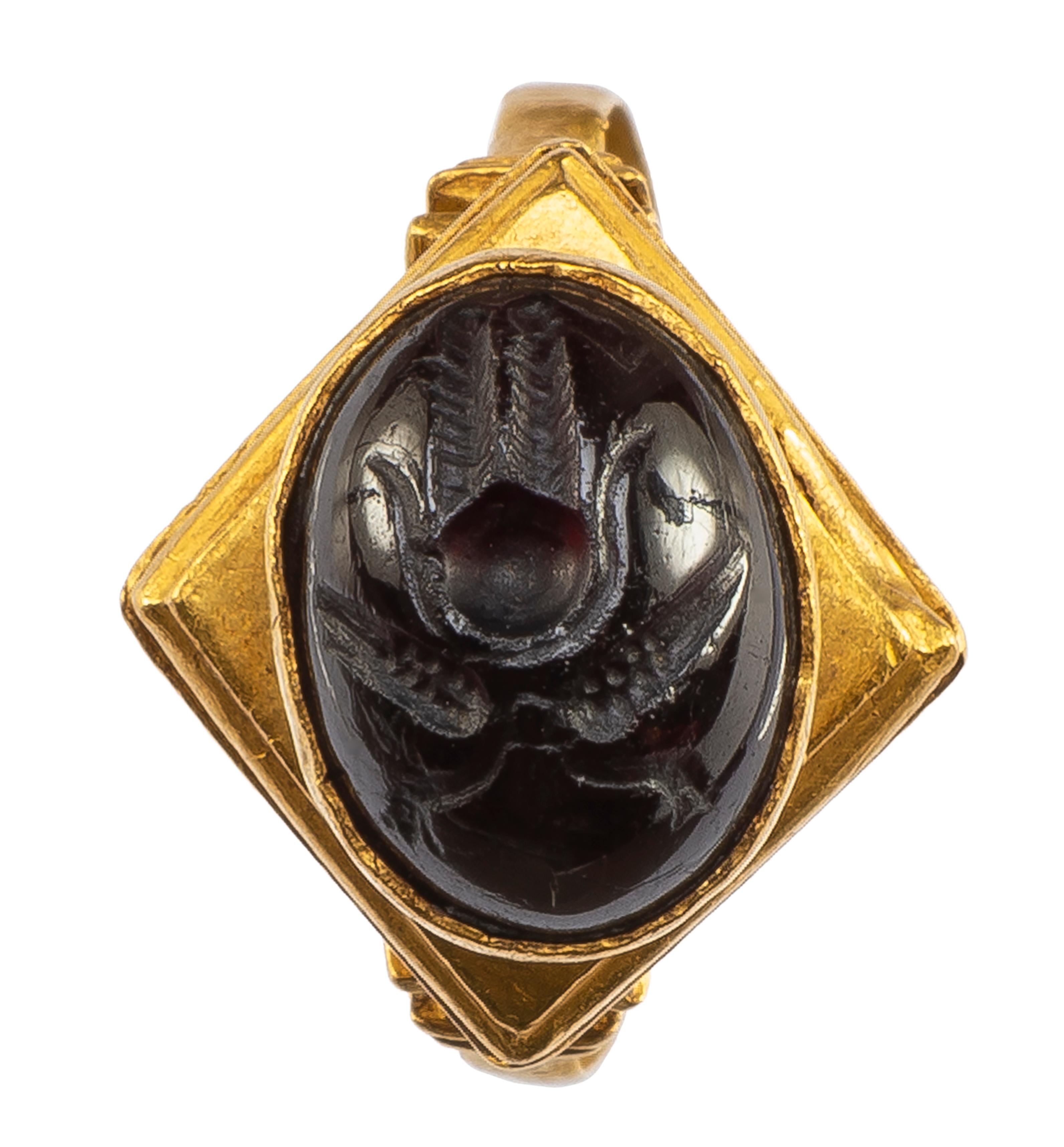 Hellenistic Ring with Garnet Intaglio  
Hellenistic,  2nd-1st century BCE  
Gold, garnet  
Weight 7.5 gr.; Circumference 58.21 mm.; US size 8½; UK size Q 3/4  

Gold ring with flat, almost “u”-shaped hoop made of gold sheet metal. The capital-like