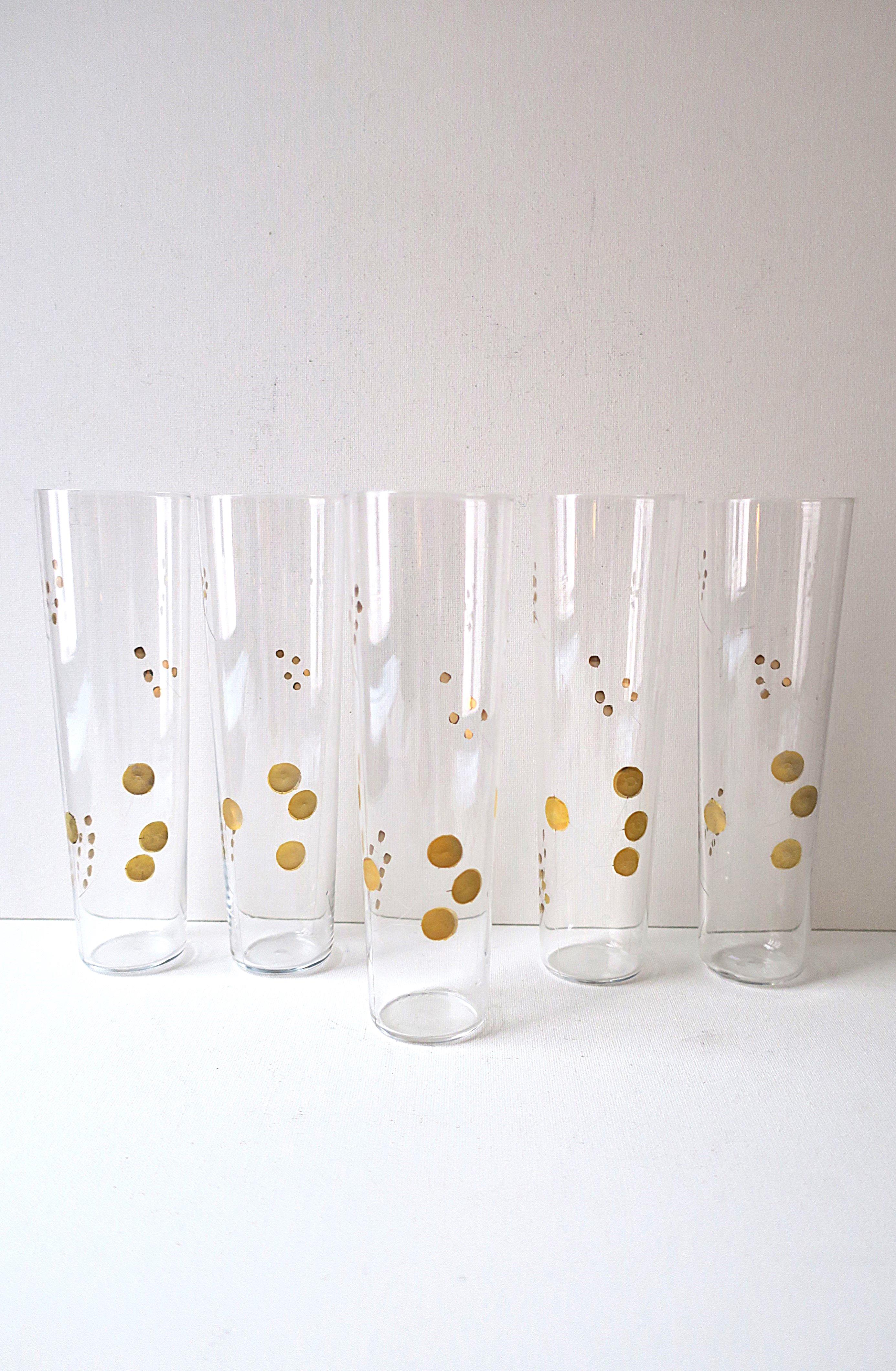 Precioso juego de cinco (5) clases de cóctel de vidrio soplado artístico con diseño grabado a mano y detalles dorados aplicados a mano, hacia mediados del siglo XX. Los vasos son altos, cónicos, grabados y pintados con un bonito diseño inspirado en