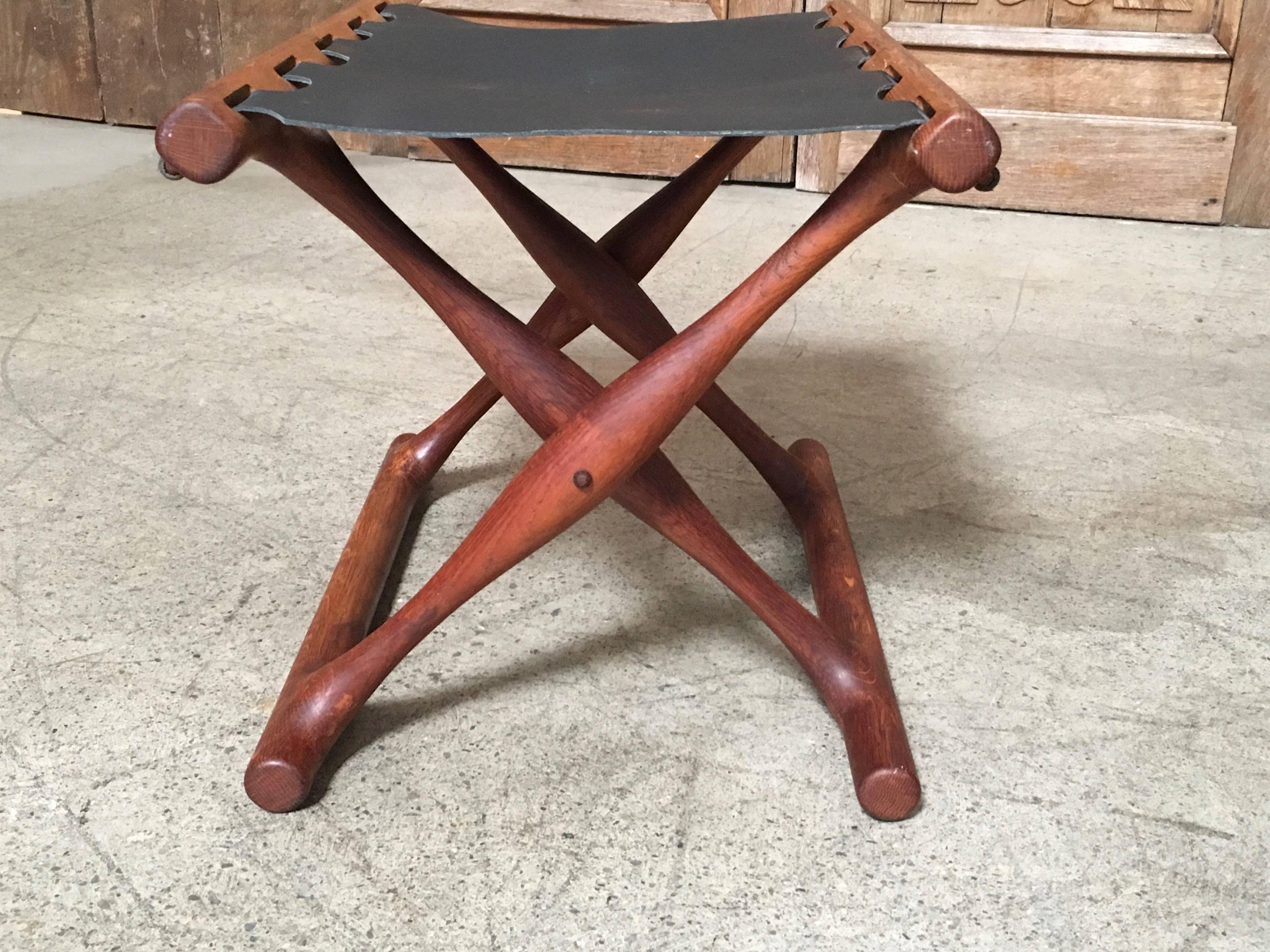 Teak and black leather folding stool designed by Poul Hundevad, circa 1950. The leather is not original.