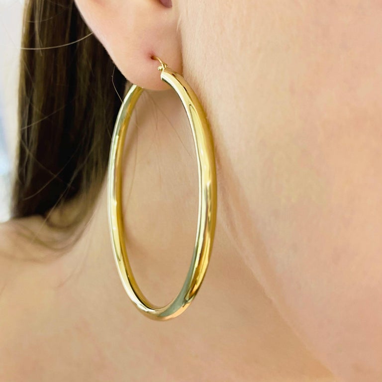 These stunning polished 14k yellow gold hoops provide a look that is both trendy and classic. While they were once worn by kings and queens to signify power and social status, hoop earrings are now considered a statement of unity and strength. Hoop