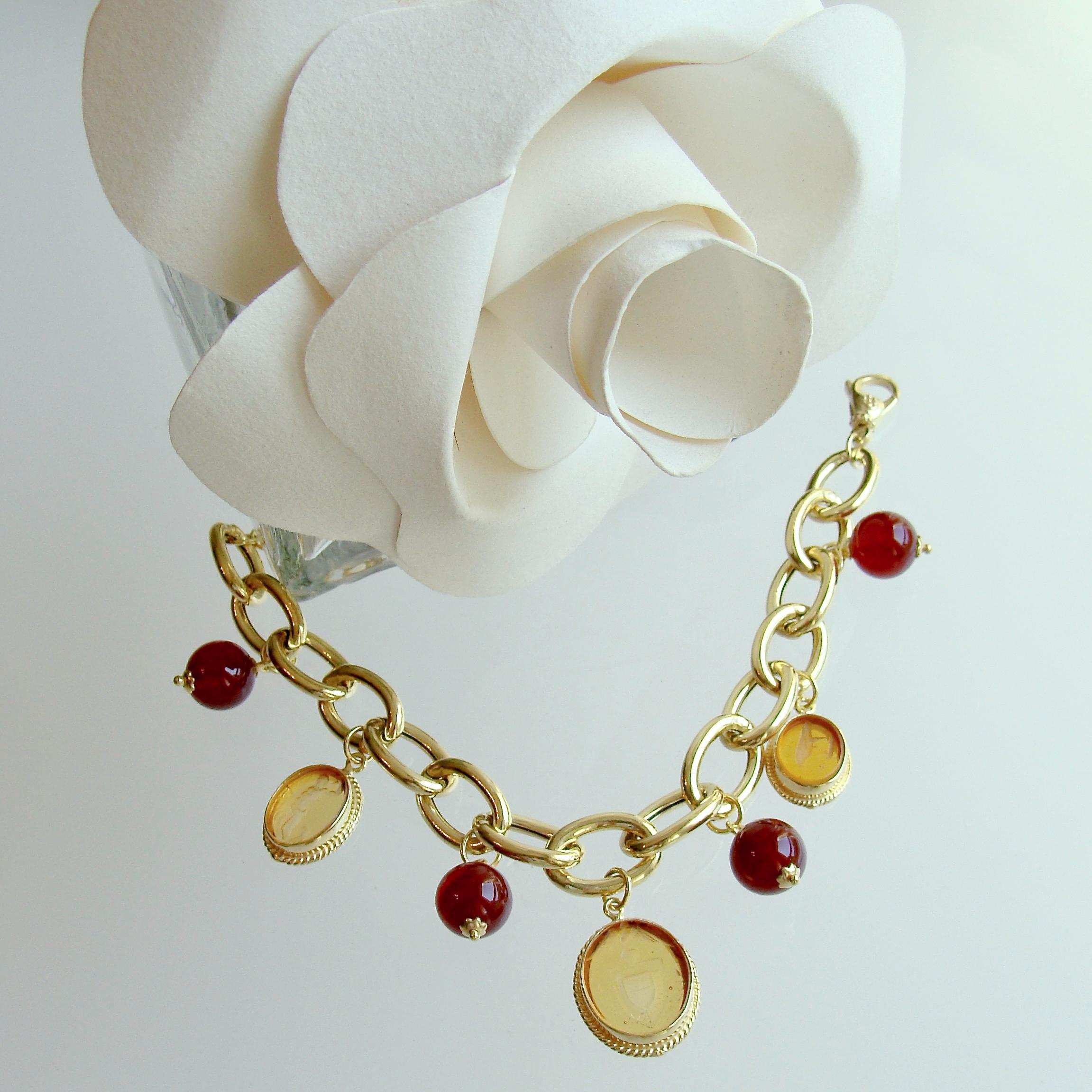 Three gold colored Venetian Glass Intaglios alternate with Carnelian beads to create this lovely “charm bracelet”.  The adjustable clasp allows the wearer to fit the bracelet to their desired position.  The root beer coloring of the Carnelian beads