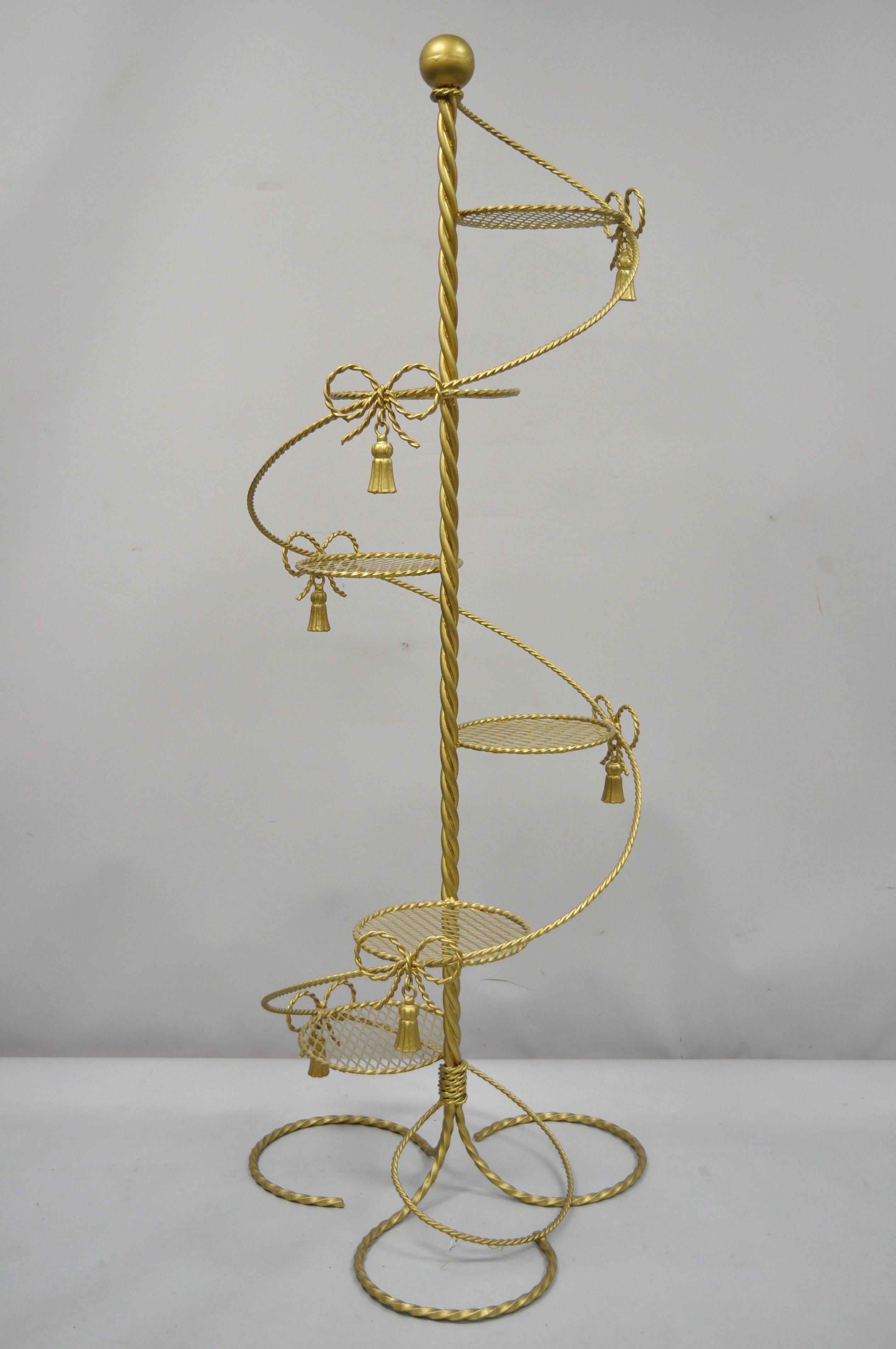 Vintage gold Italian Hollywood Regency iron spiral staircase tall plant stand. Item features 6 plant stands, rope design, bow and tassel accents, spiral staircase frame, wrought iron construction, quality craftsmanship, great style and form, circa