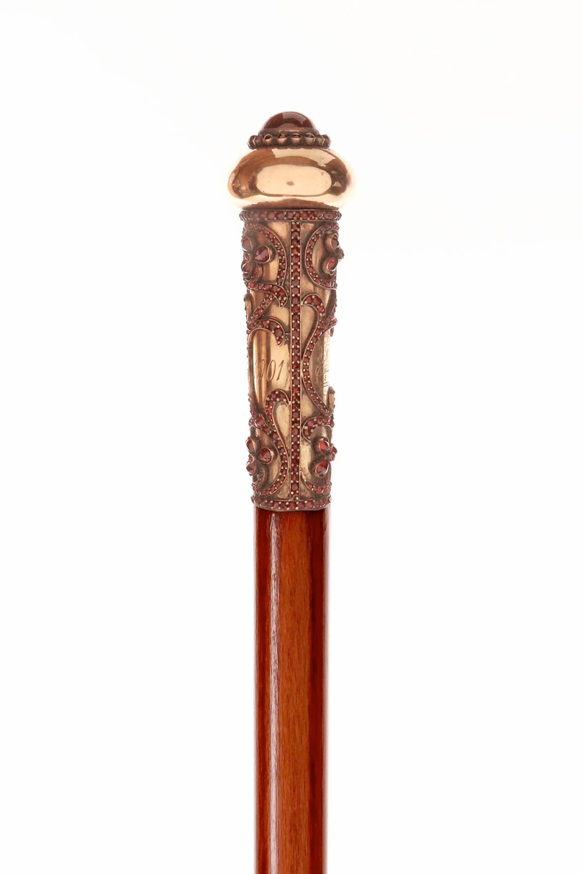 Canne : canne en bijou avec pommeau en or milord et pierres de grenat facettées, représentant des trèfles. Gravée d'une dédicace Noèl, d'une date 1910 et des armoiries des Calvi di Bergolo, une famille de la petite noblesse de Savoy apparentée au