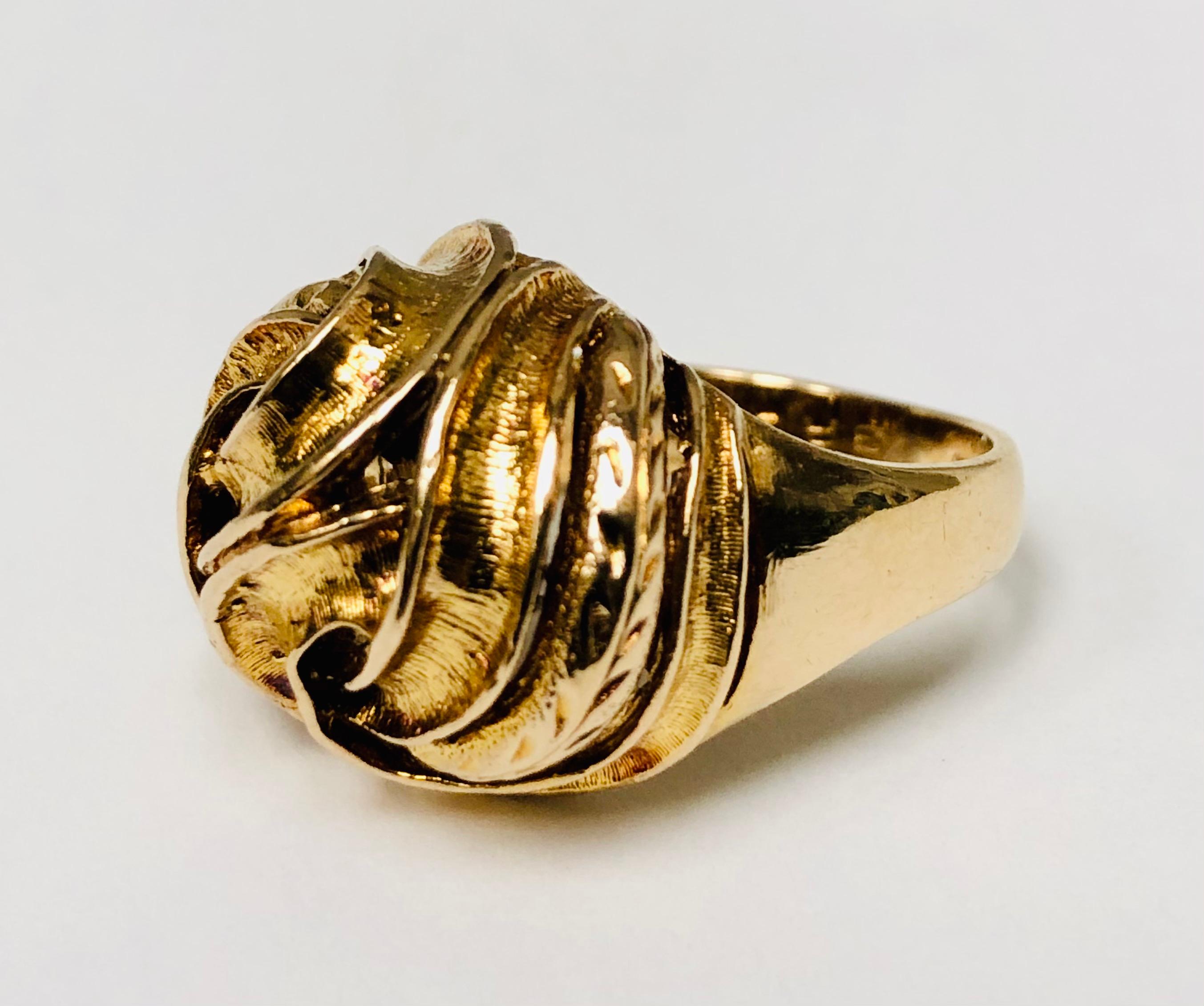 A love knot and gold dome ring in one lovely interwoven vintage jewel. A seamlessly intertwined 1970's, 9 karat gold dome ring made in the United Kingdom circa 1972. Ring size 6. Makers mark ML. Anchor stamp for Birmingham, England. 

Height 1.1 cm