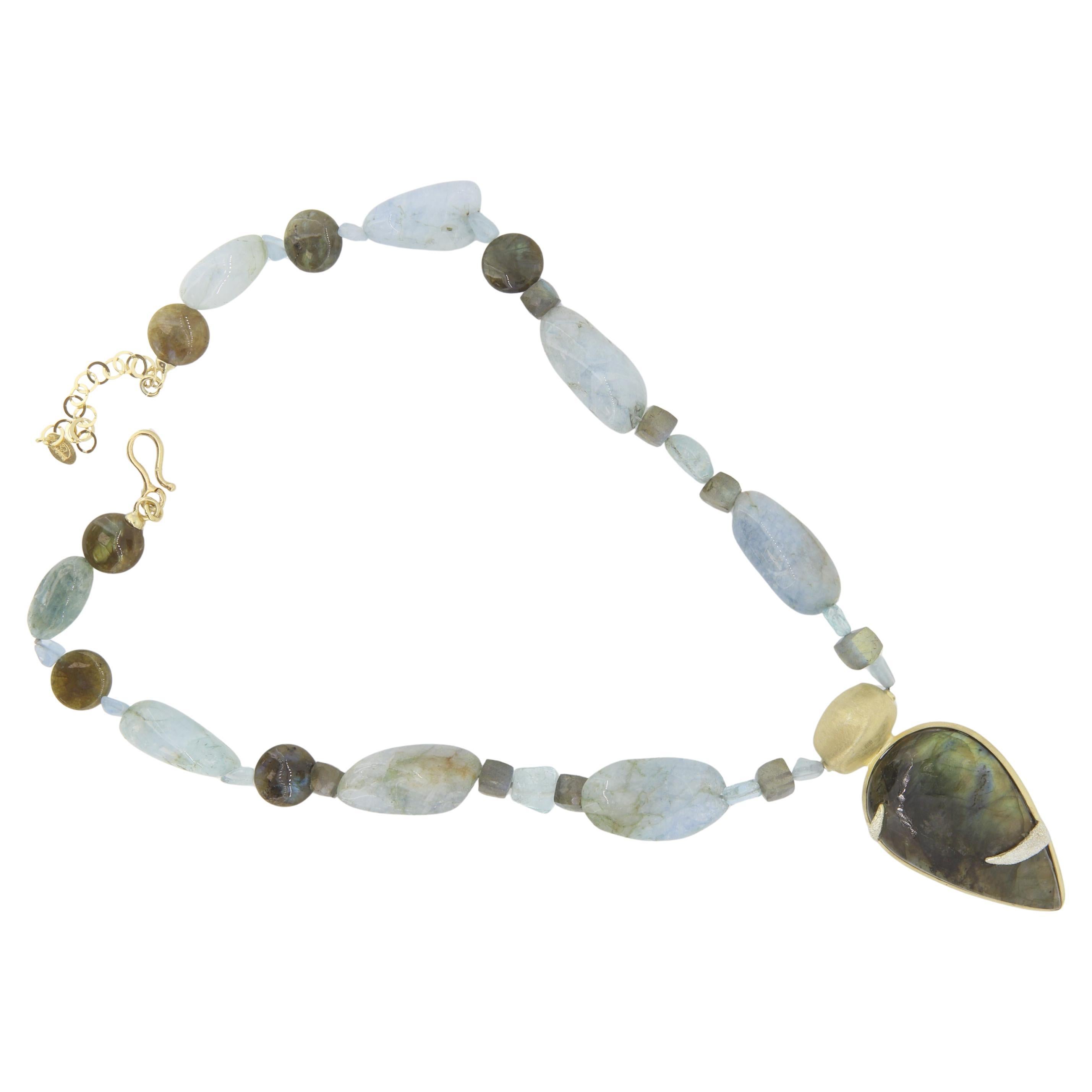 Eleva il tuo look con questa splendida collana artigianale di 22 pollici, caratterizzata da un'affascinante miscela di pietre sfaccettate di labradorite e acquamarina. Al centro, un sorprendente ciondolo di labradorite a forma di goccia è