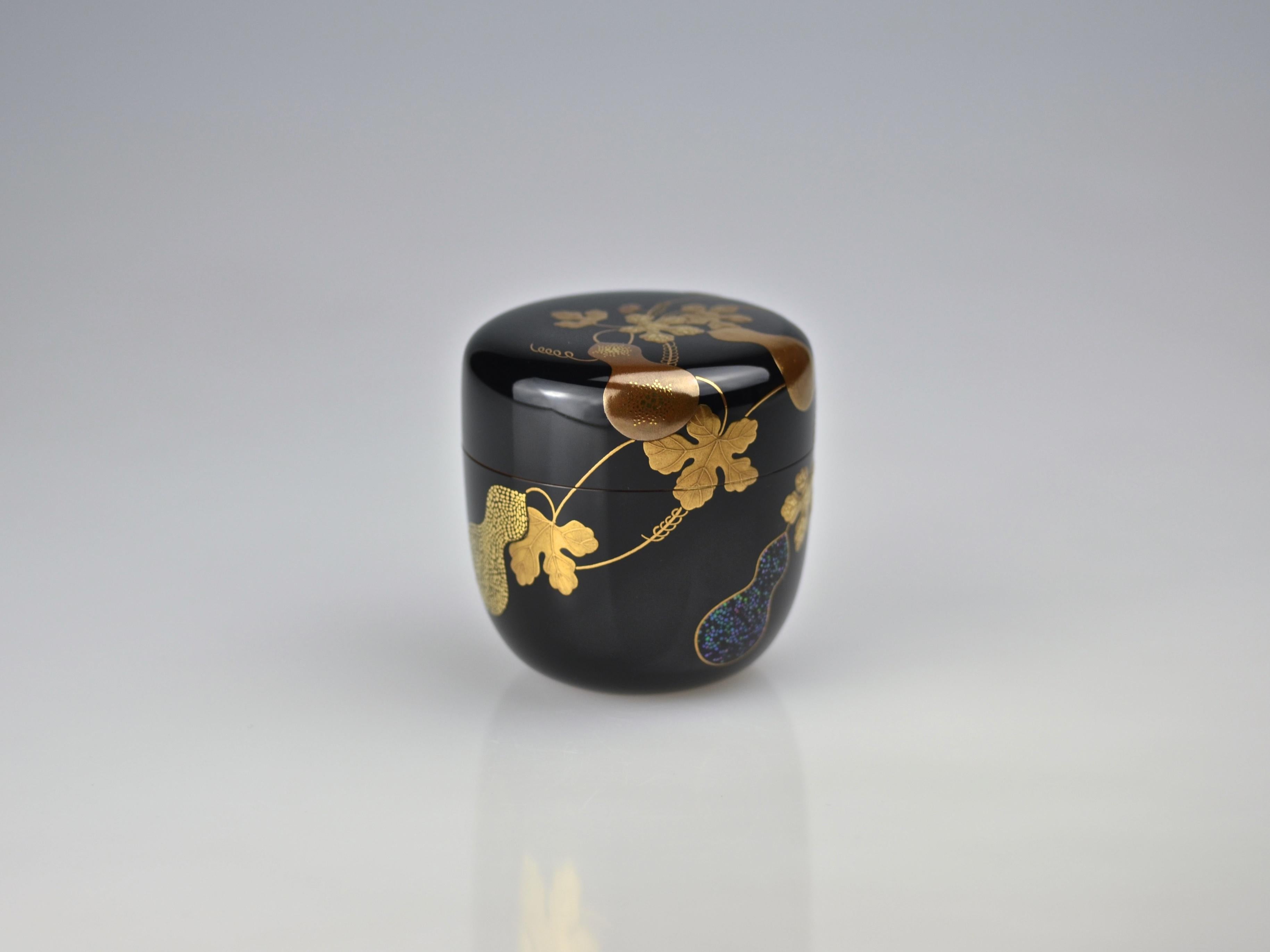 Excellent tea caddy (natsume) made by the 7th Ippyosai, Ippyo Eizo (1942). The exterior is finished in polished jet black lacquer (roiro) and decorated in gold maki-e with twines of gourds (hisago or hyotan). Gourds are the very symbol of the this