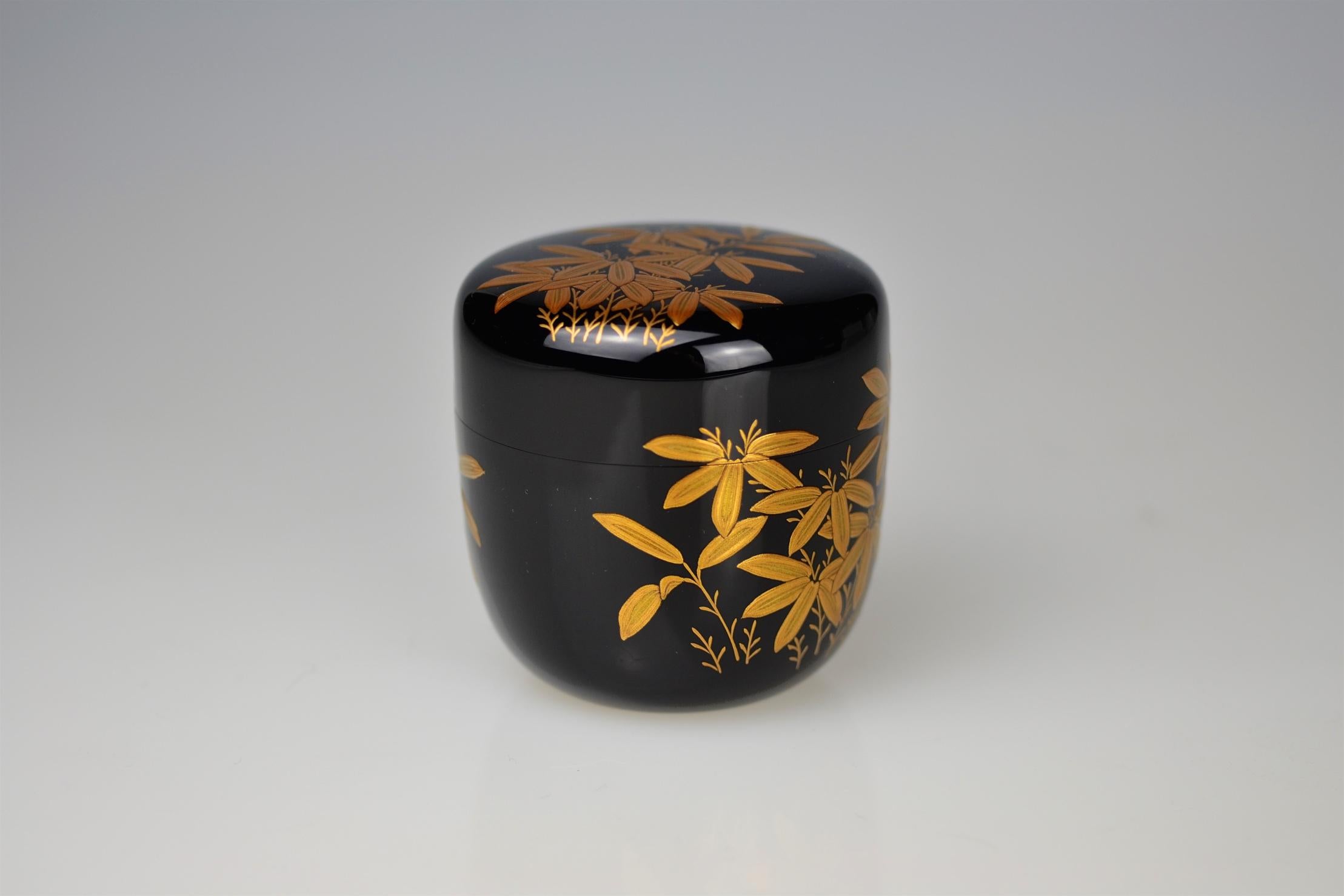 Excellent tea caddy (natsume) made by the 7th Ippyôsai, Ippyô Eizô (*1942). The exterior is finished in polished jet black lacquer (roiro) and decorated in gold maki-e with branches of bamboo grass (sasa). Interior and base in sprinkled gold