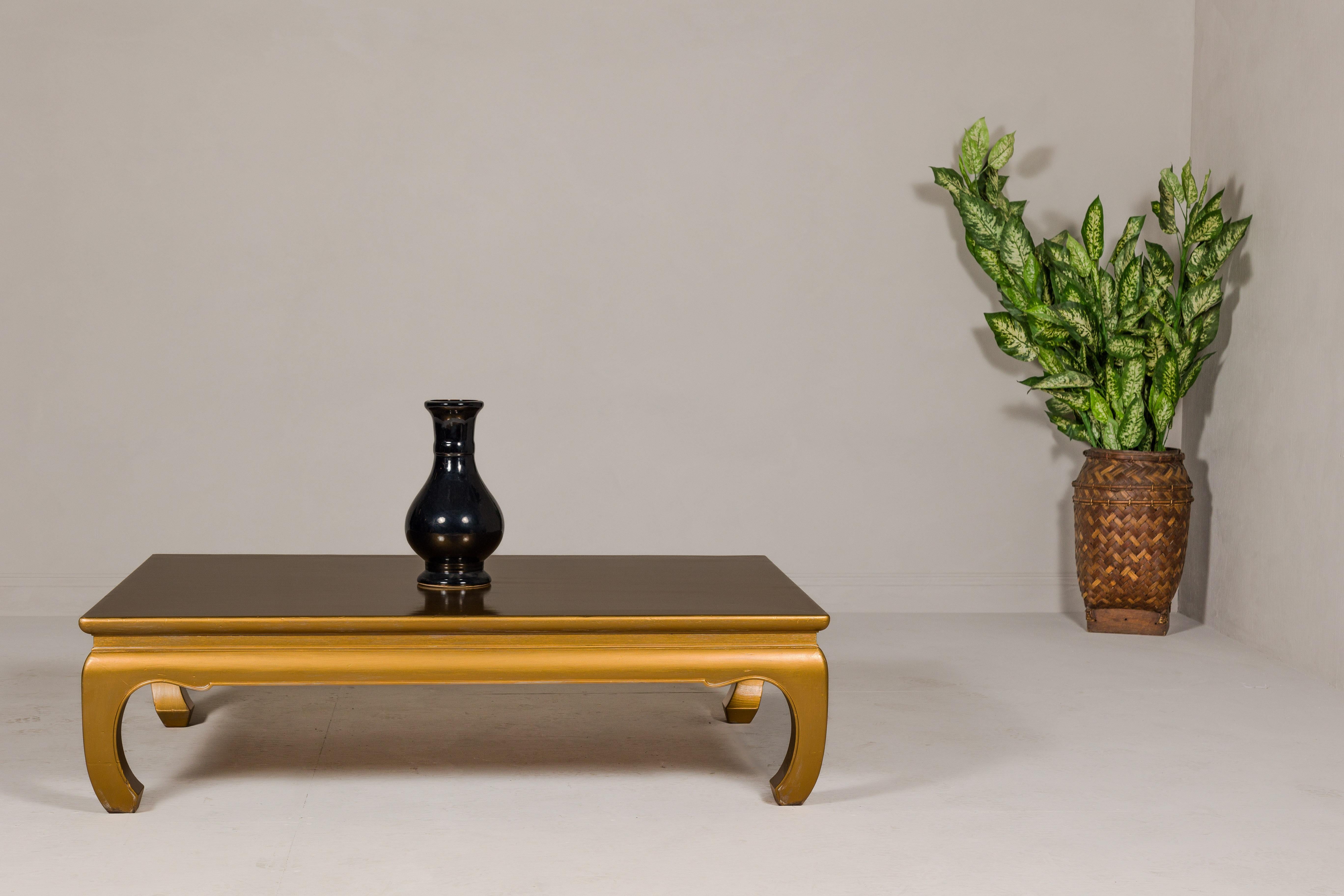 A Ming Dynasty style gold lacquered chow leg coffee table with carved apron. This vintage Ming Dynasty style coffee table, exquisitely refinished to highlight its historic charm, is a testament to the timeless elegance of Chinese furniture design.