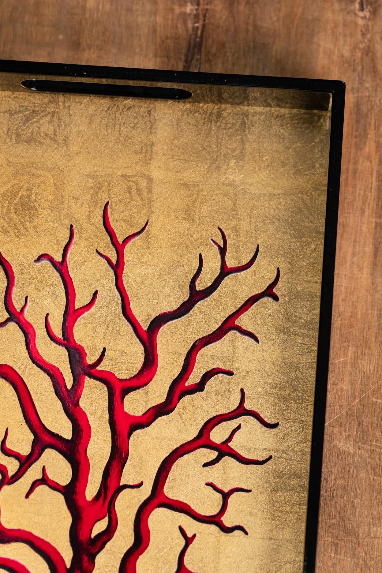 Bold and playful, this lacquered wooden tray features a gold background adorned with a red coral motif. Finished with a smooth, glossy surface and practical cut-out handles, it’s perfect for serving drinks, appetisers, or simply as a decorative