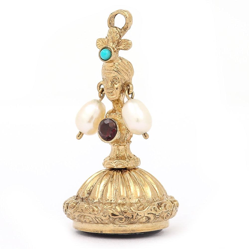 A 9 karat yellow gold ornate scroll seal fob with a blank amethyst base. This is a fob that echoes Georgian and Victorian design that has been made in the mid 1990’s. The actual decoration displays the form of a woman with turquoise set turban,