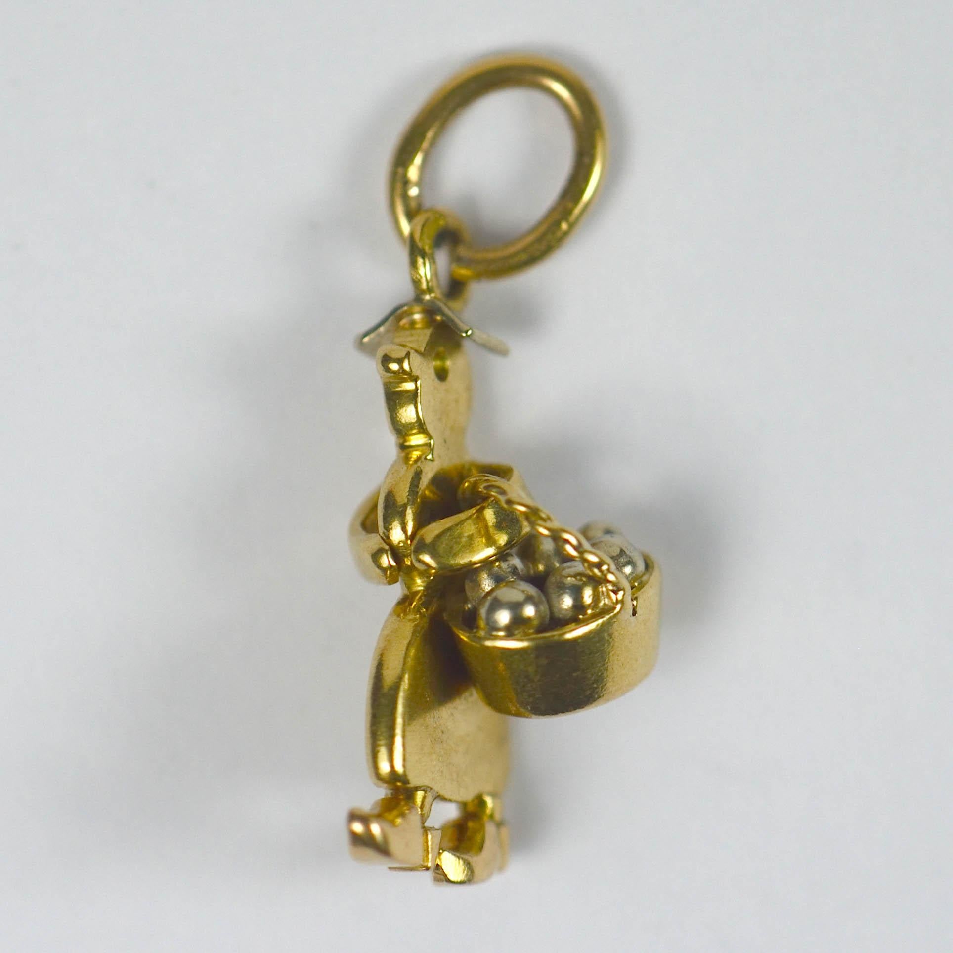An amusing charm which probably formed part of the Cartier nursery set of charms. 

Designed as a lady carrying a basket of goods in white and yellow gold, it is stamped with the French eagle's head for 18 karat gold. 

Dimensions: 3/4